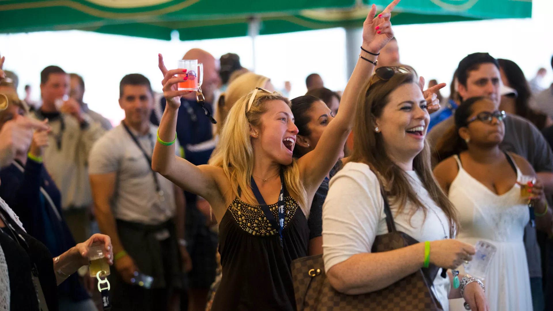 Woman with beer tasting in her hand singing at NJ Beer and Food Festival.