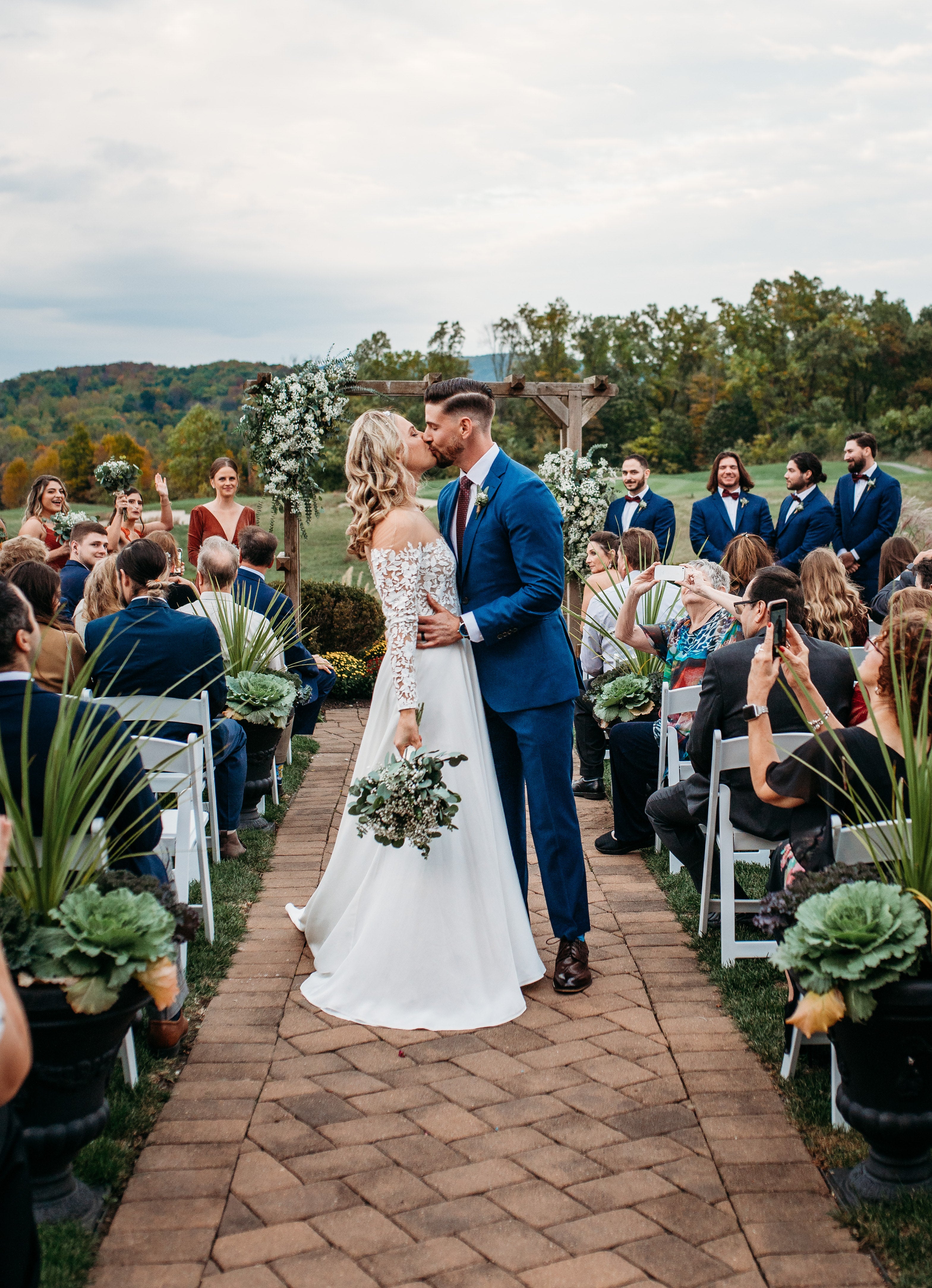 Bride and groom kiss while walking down the aisle at the Ballyowen wedding garden fall ceremony.