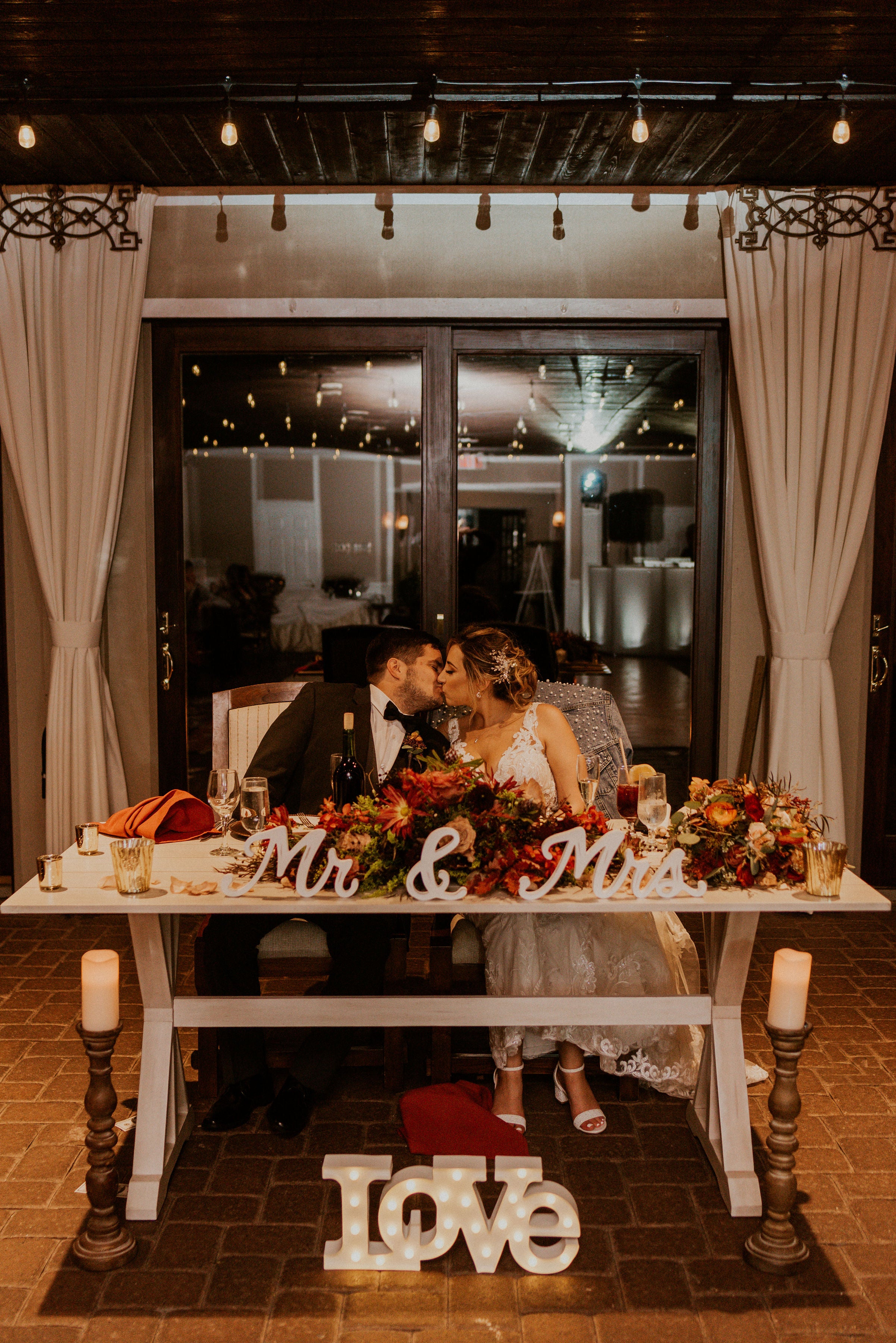 Bride and groom kiss at their sweetheart table during their Bailigh Bluff House Ballyowen wedding reception.