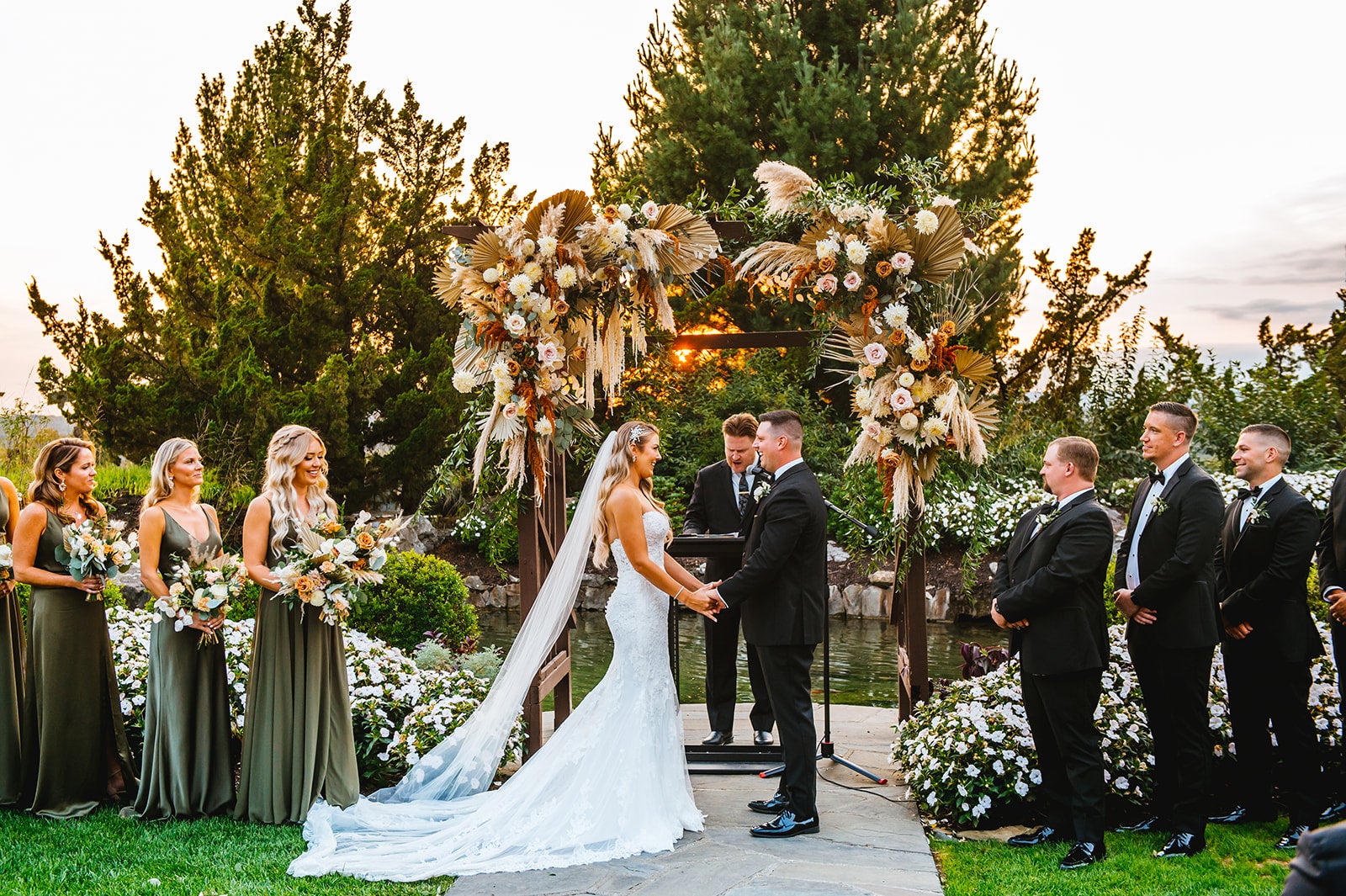Bride and groom stand hand in hand at Bride walking down the aisle at Wedding Garden ceremony space at Crystal Springs Country Club. 
