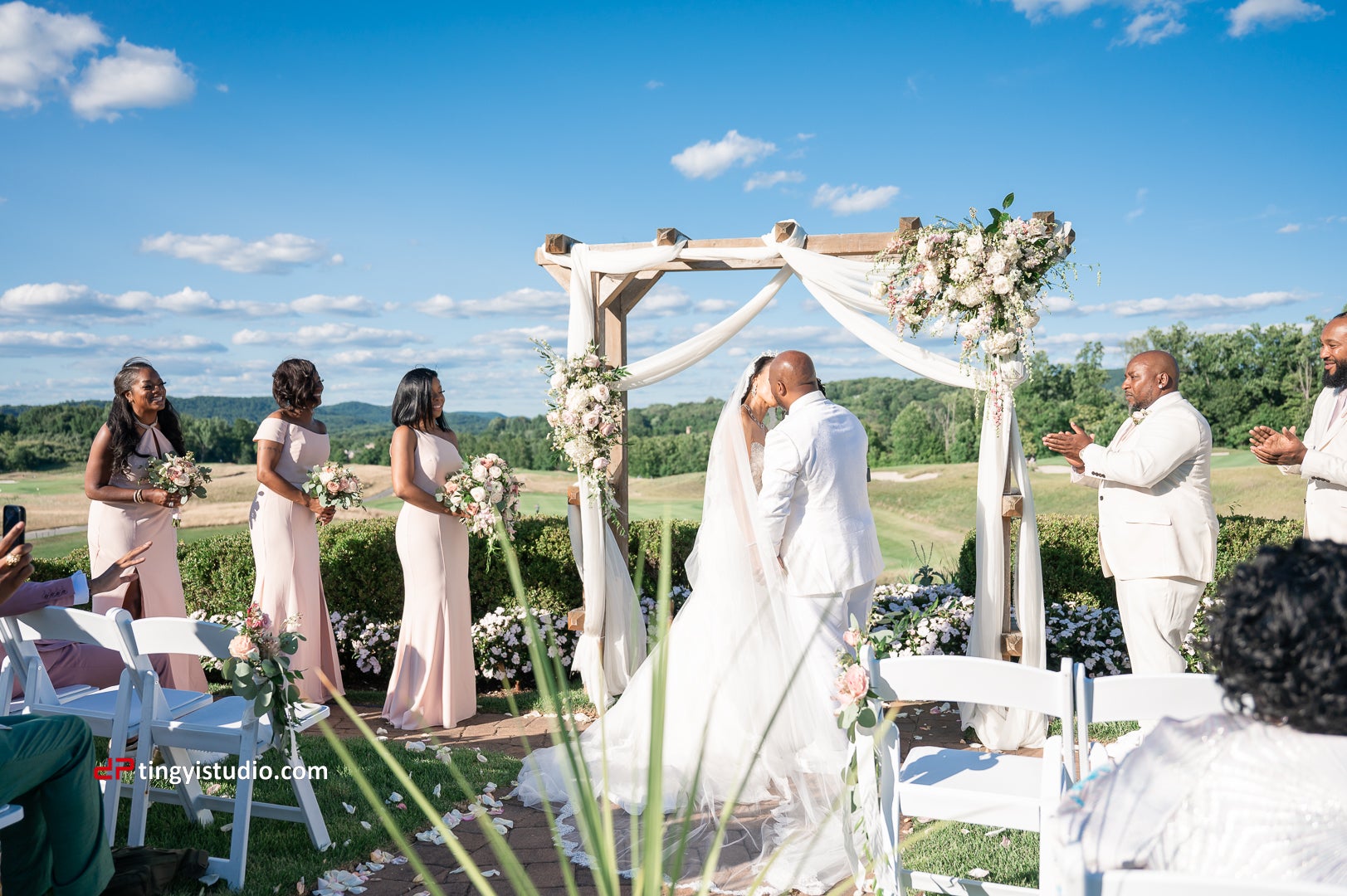 Bride and groom kiss during their wedding ceremony at Ballyowen Wedding Garden