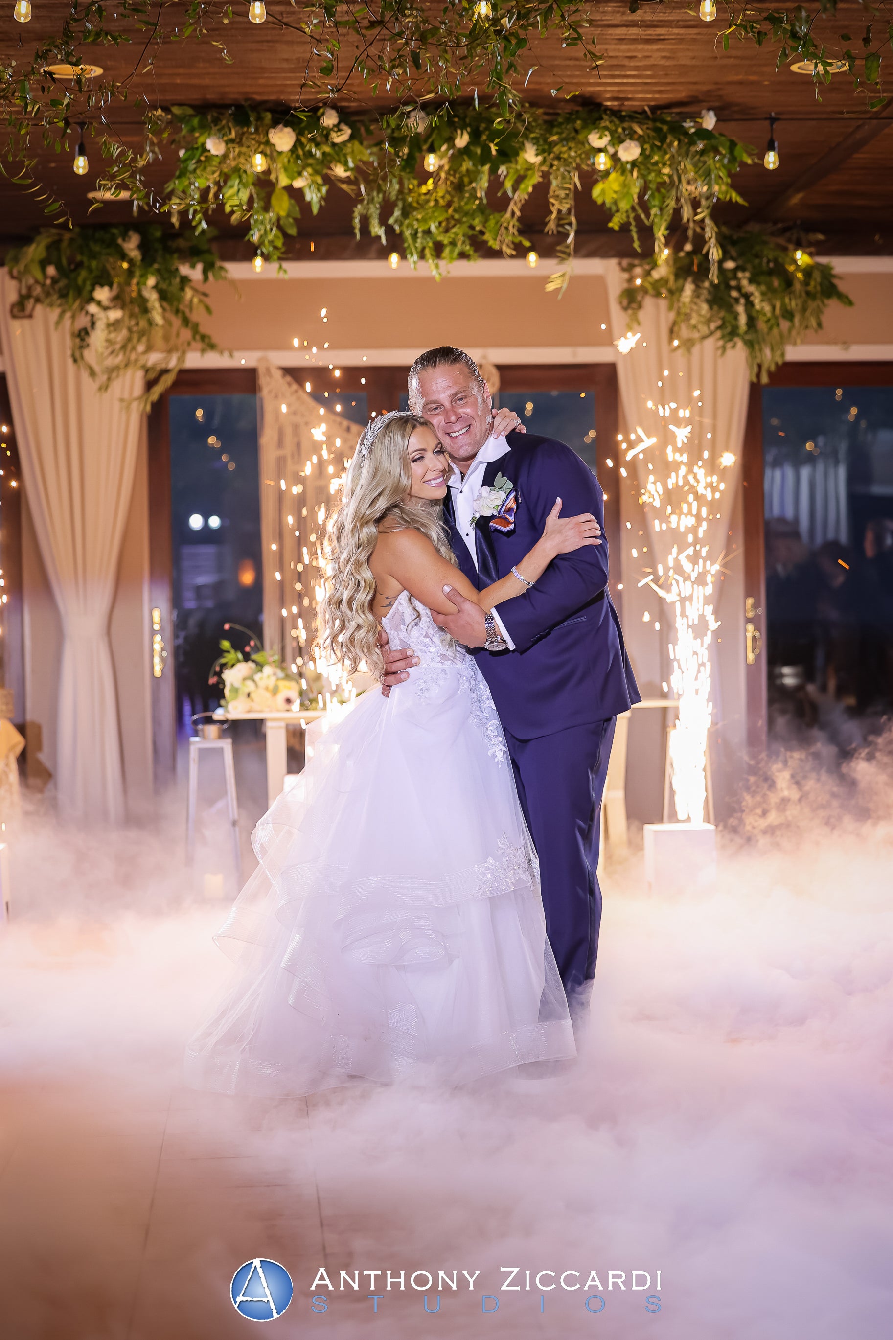 Couple hugging as they stand in fog on the dance floor during their Bailigh Bluff House wedding reception.