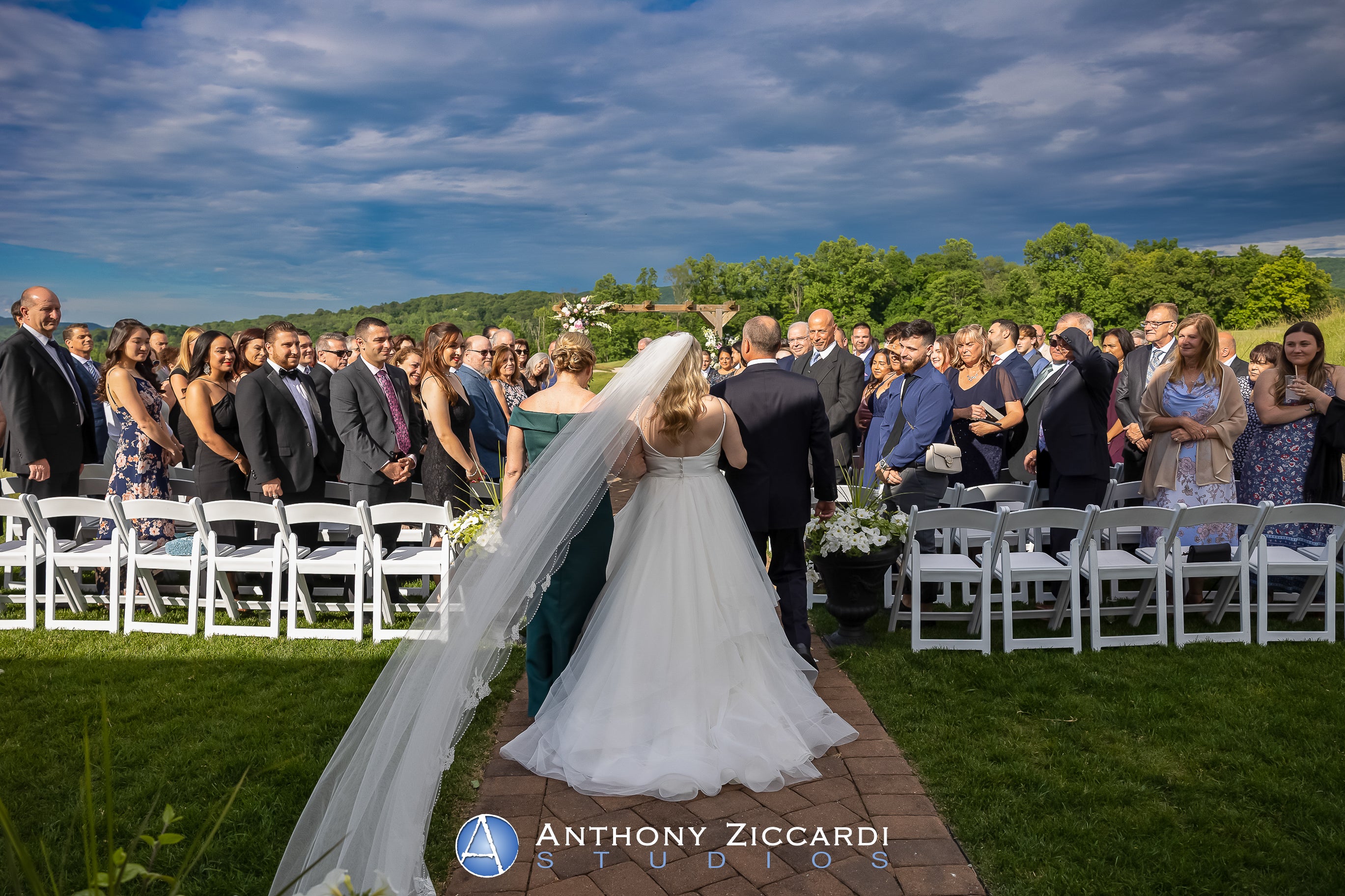 Bride walks down aisle with mother and father during her Ballyowen wedding garden ceremony. 