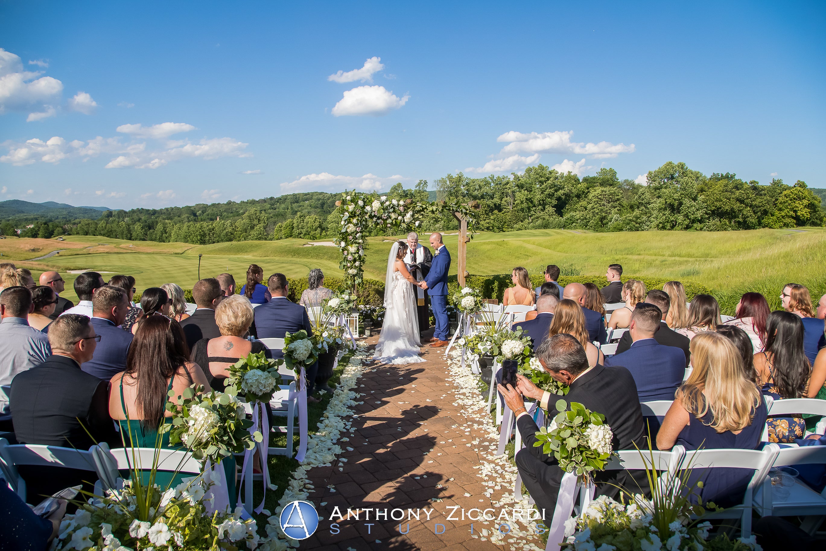 Bride and groom hold hand during their ceremony at Ballyowen Wedding Garden.