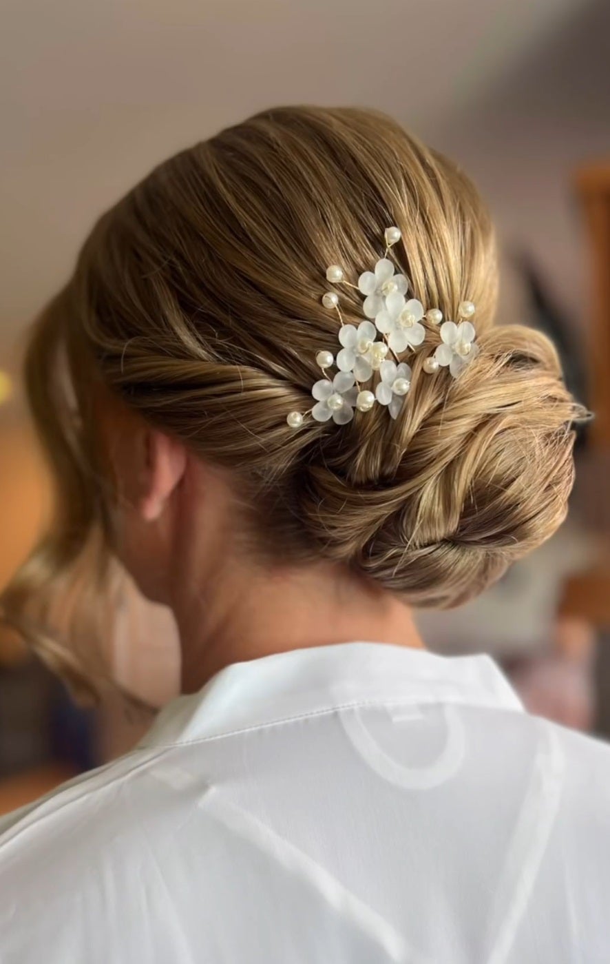 Up do hairstyle featuring gold flower. 