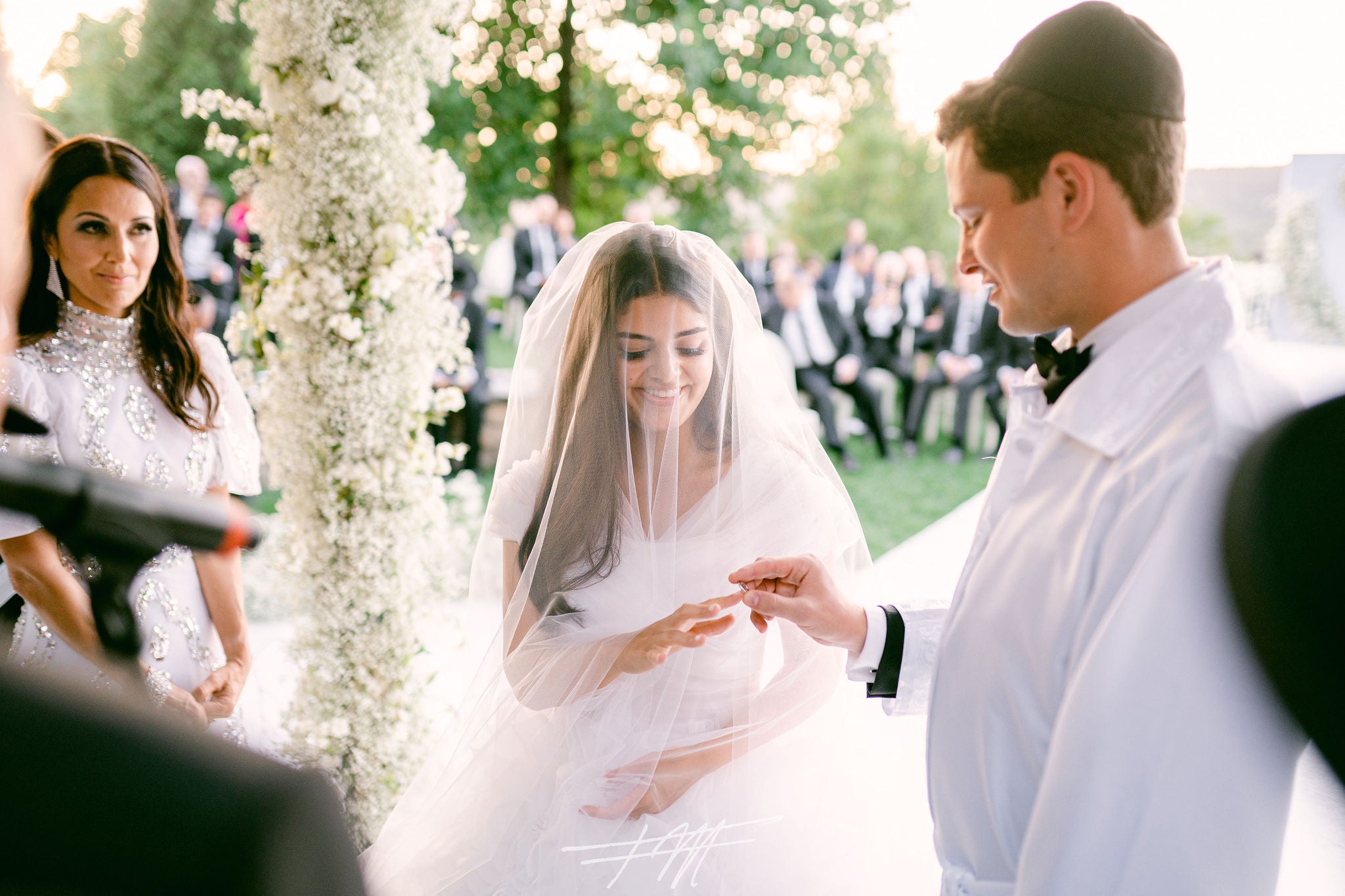 Groom putting ring on bride's finger during their amphitheatre ceremony.