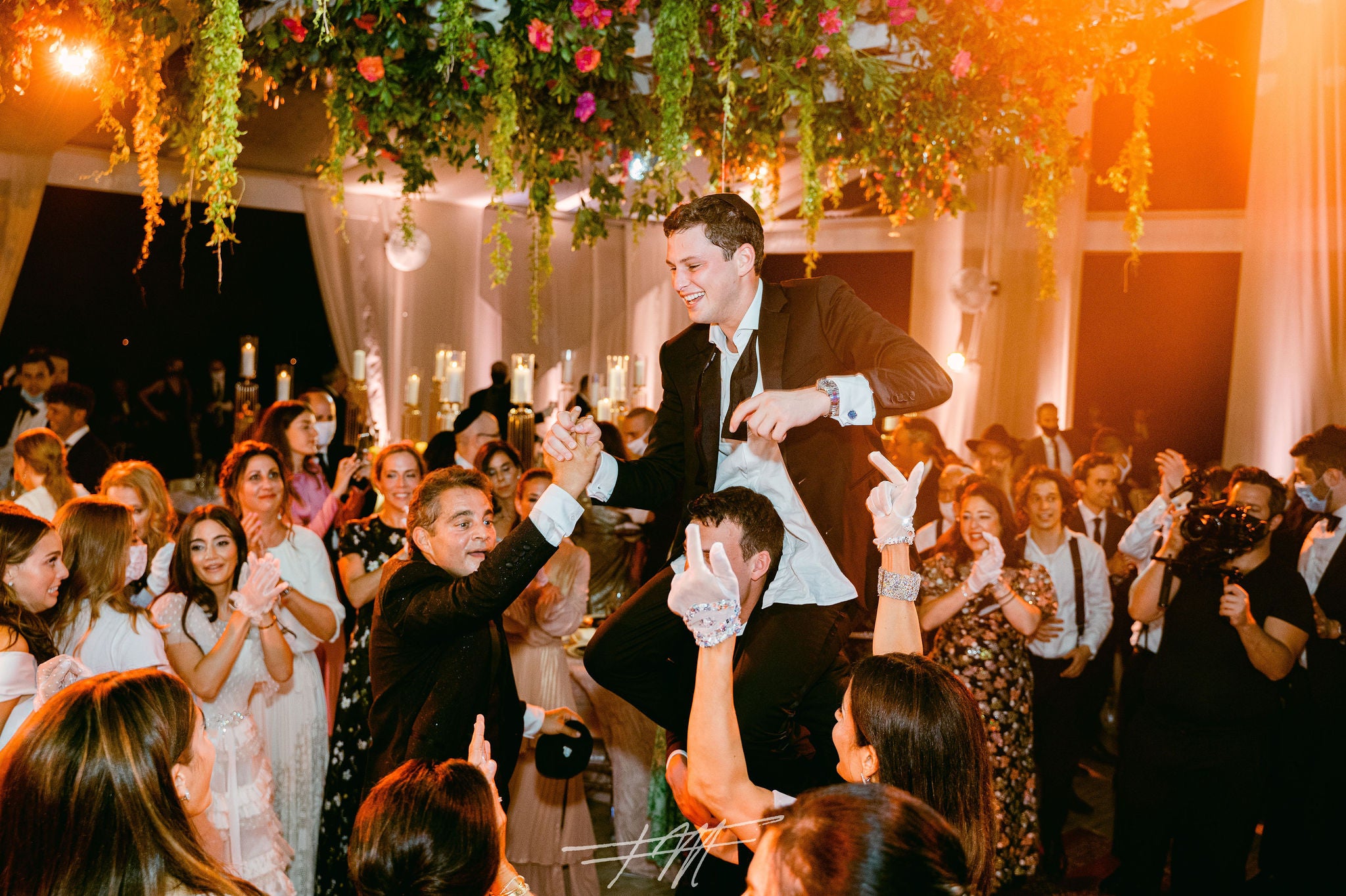 Groom being lifted in air during wedding reception at Big Sky Pavillion.