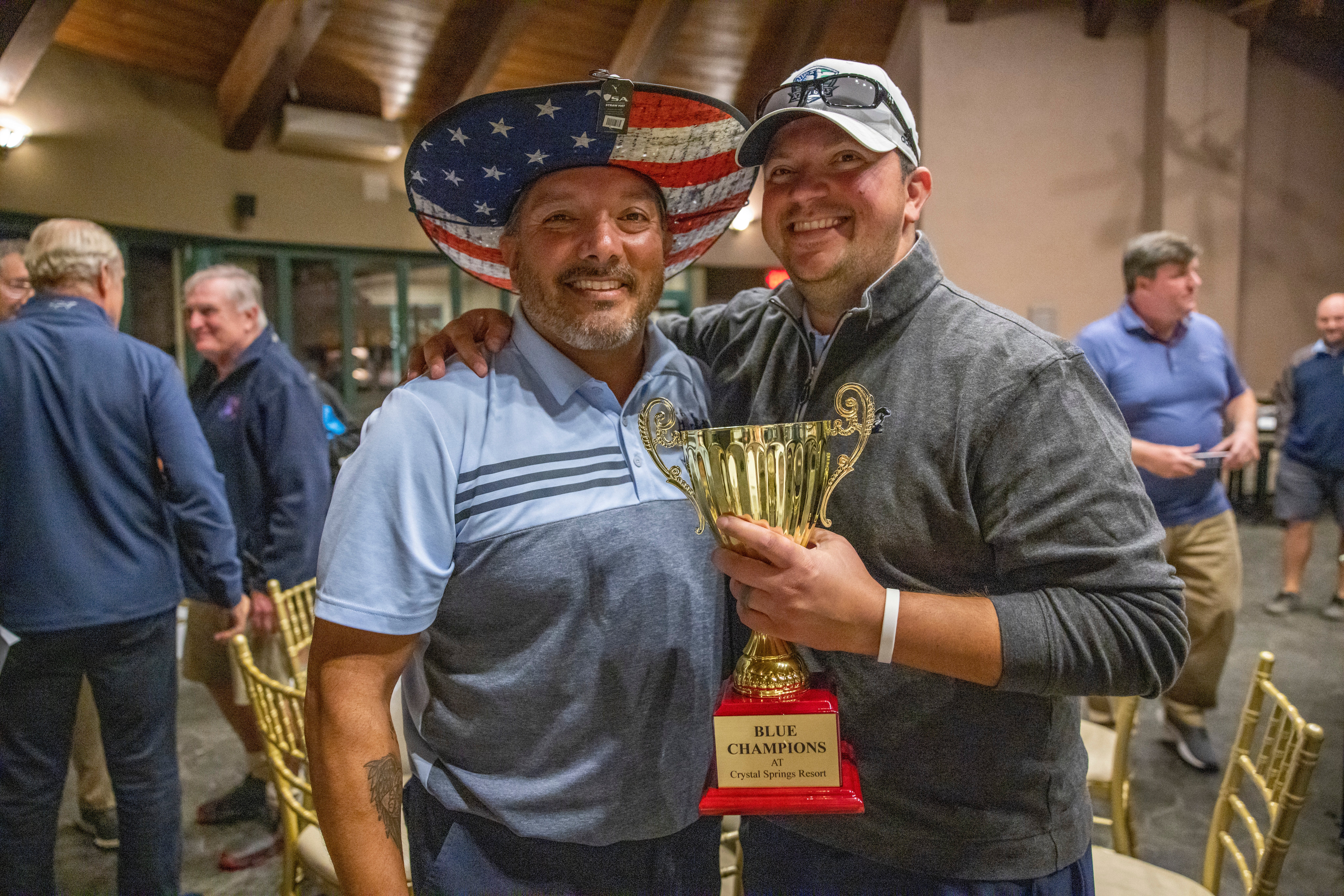 Law Enforcement Open golfers standing with gold trophy. 