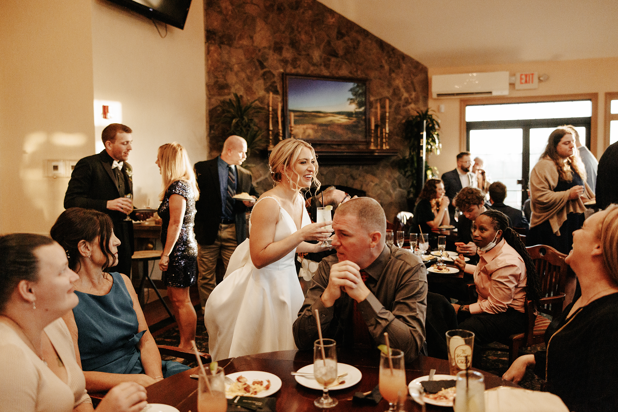 Bride holding drink during cocktail hour.