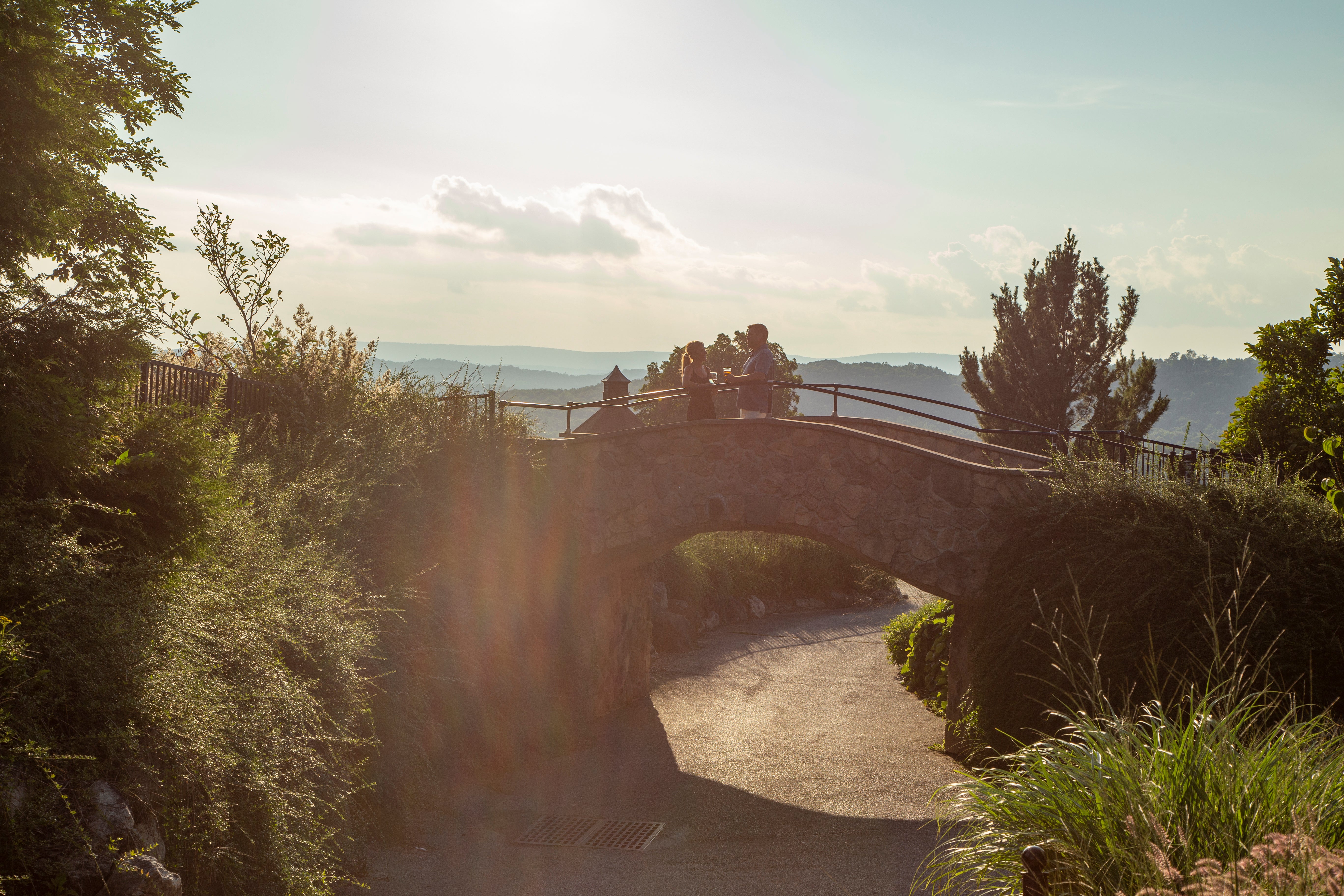 Man and woman standing on bridge talking.