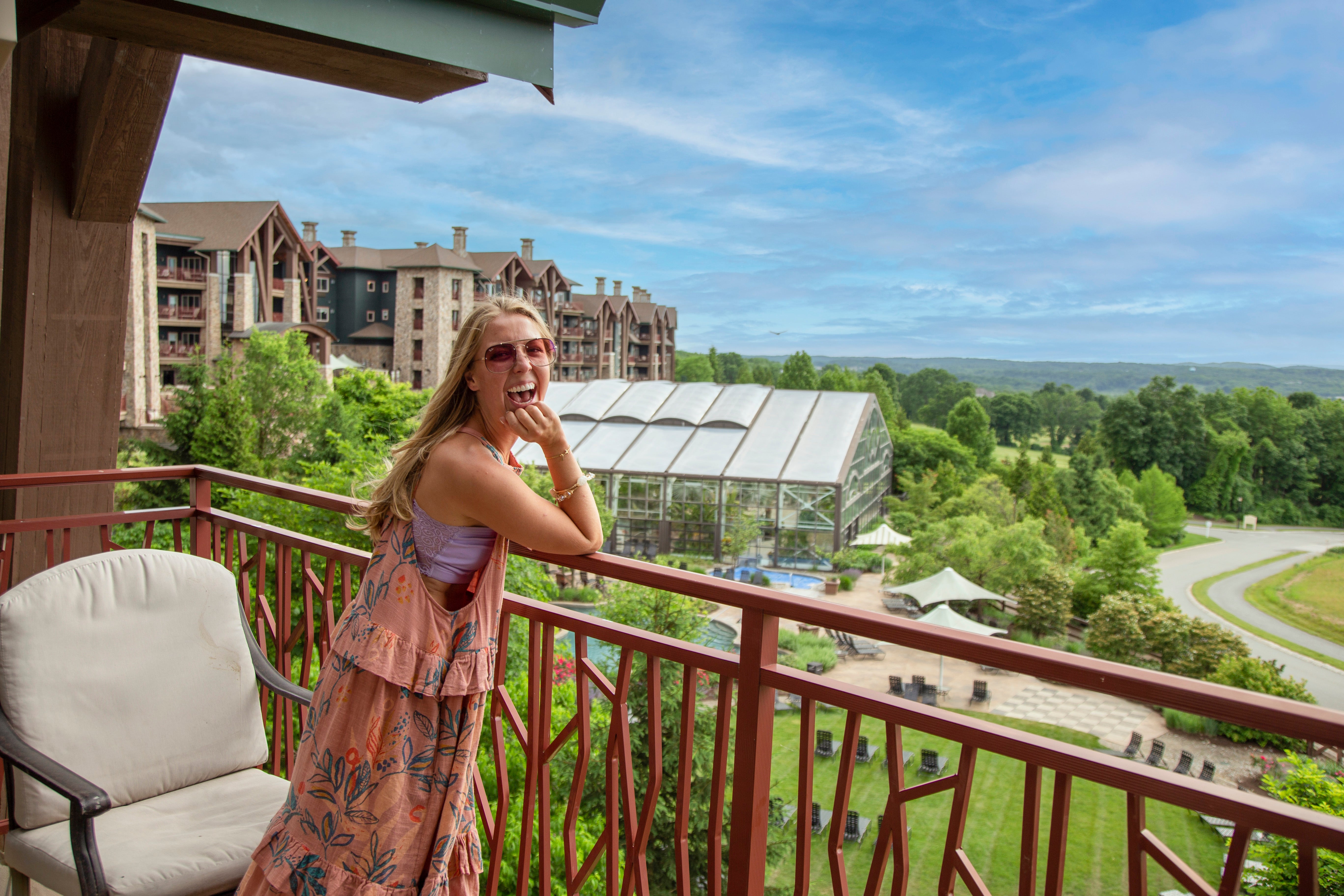 Woman standing on Grand Cascades Lodge balcony. 