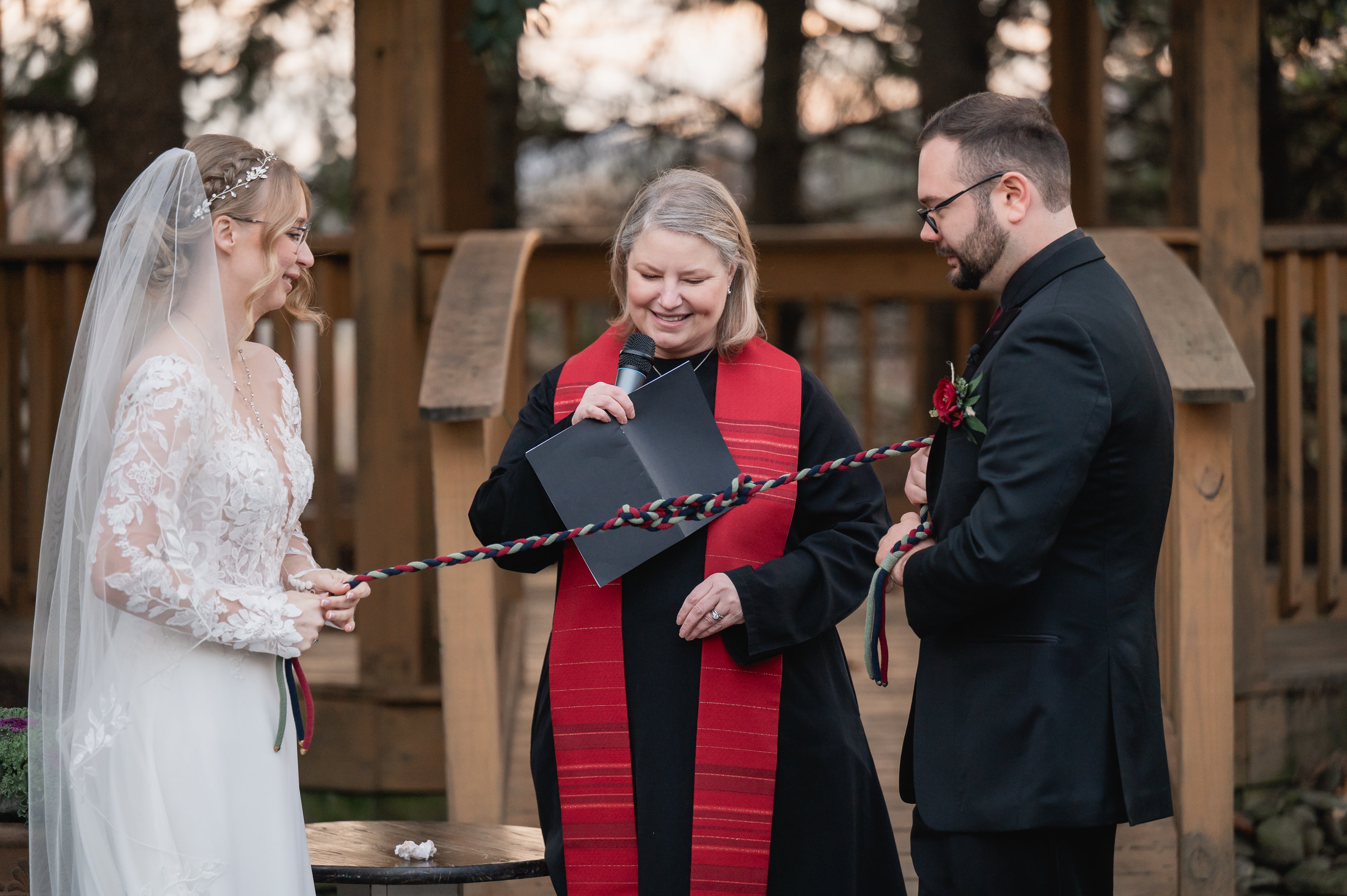 Bride, groom and officiant stand at altar at Black Bear wedding ceremony. 