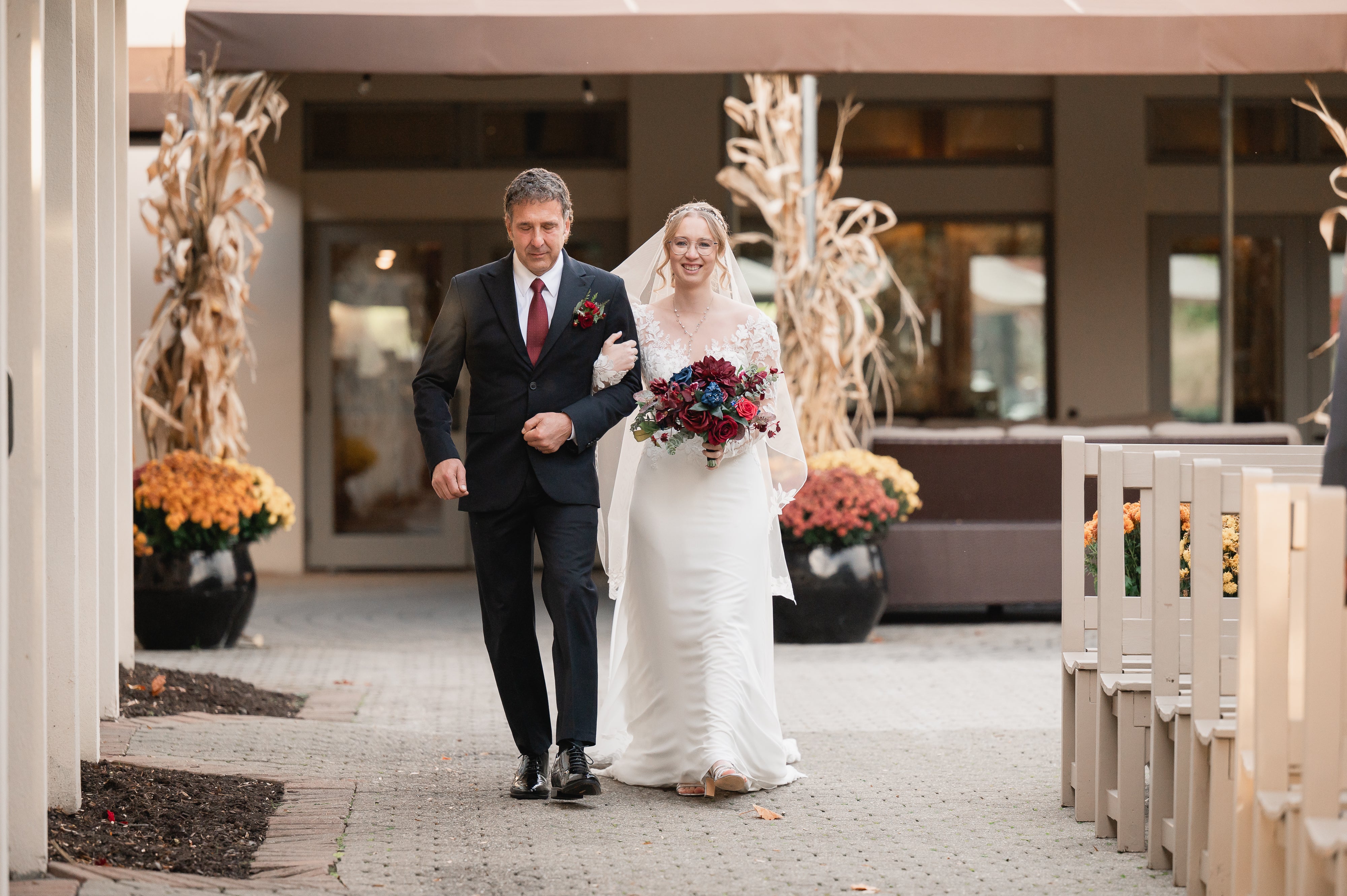 Bride and man walk down aisle together at Blac Bear wedding ceremony.
