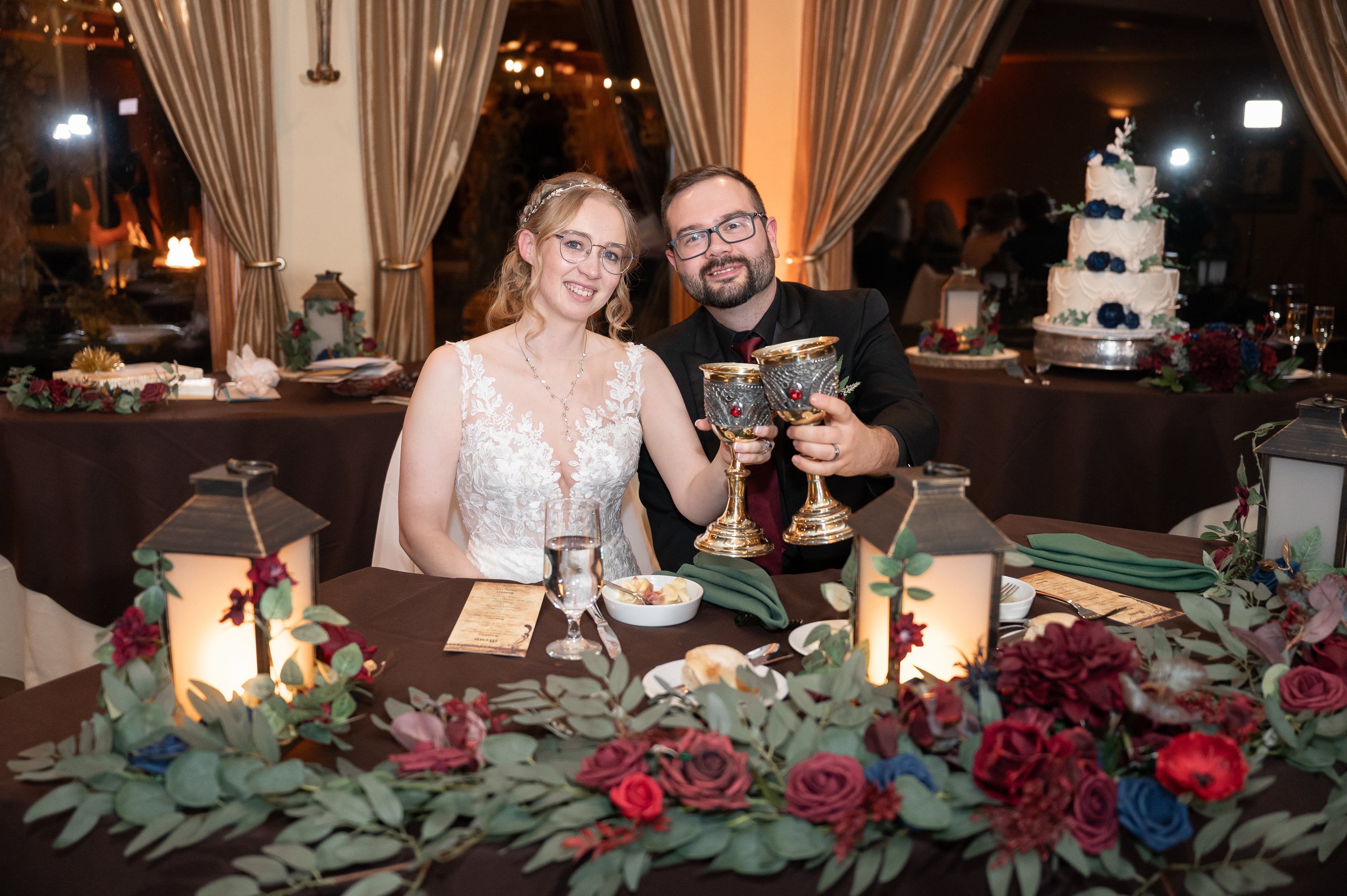 Bride and groom cheers as they sit at honeymoon table during their Black Bear wedding.