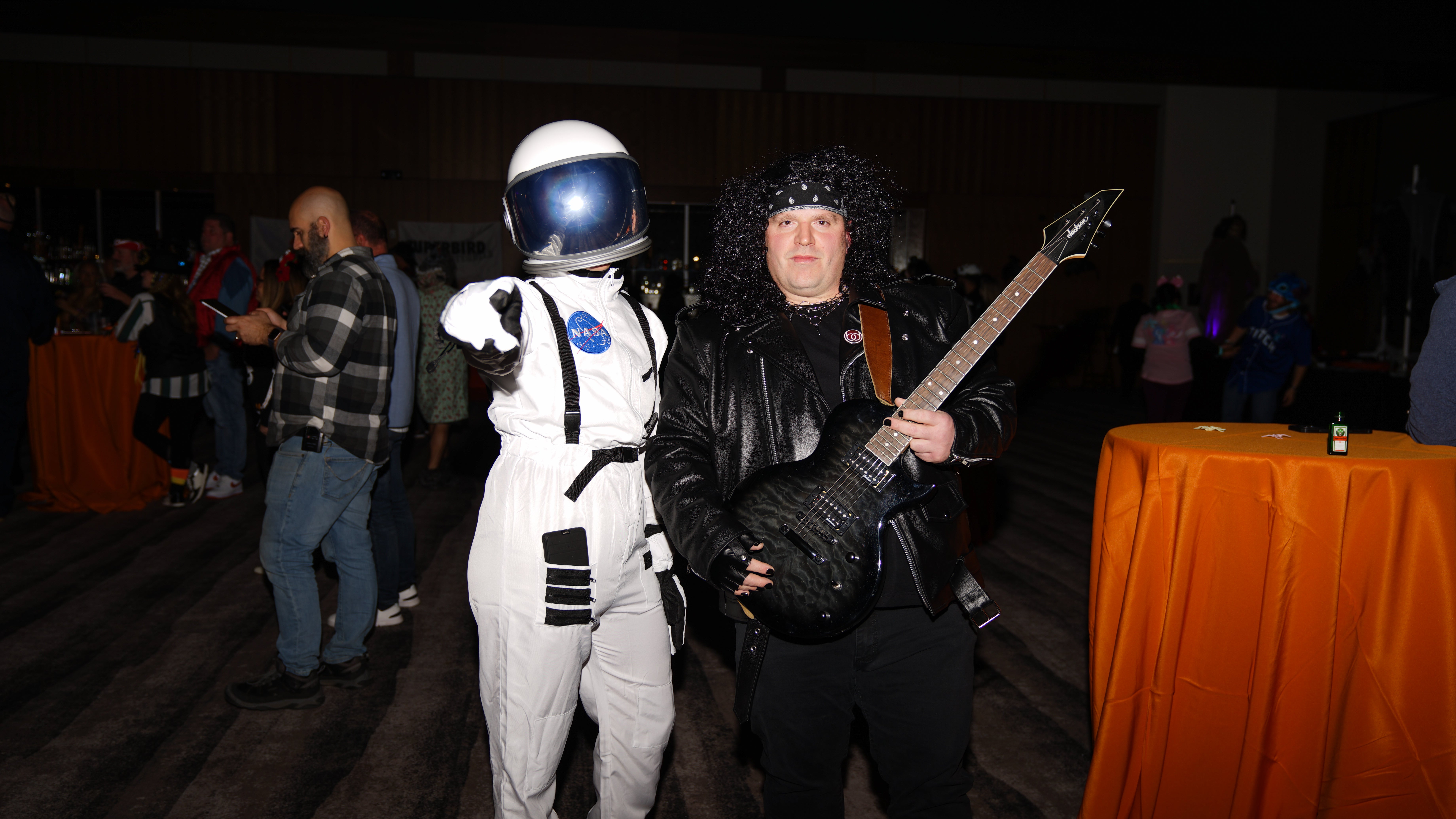 Two people dressed up as astronaut and rockstar.