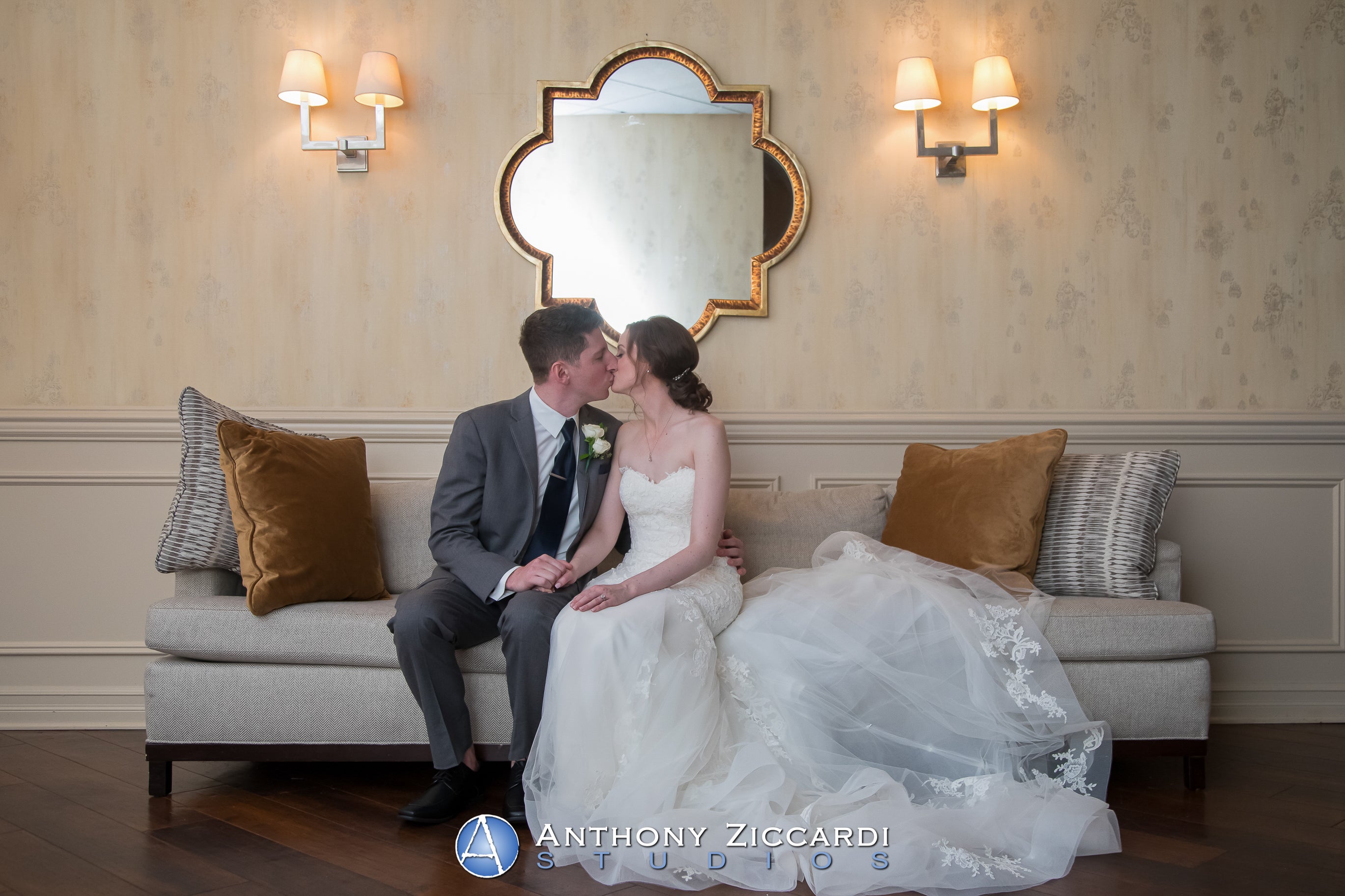 Bride and groom sit on couch outside Diamond Ballroom.