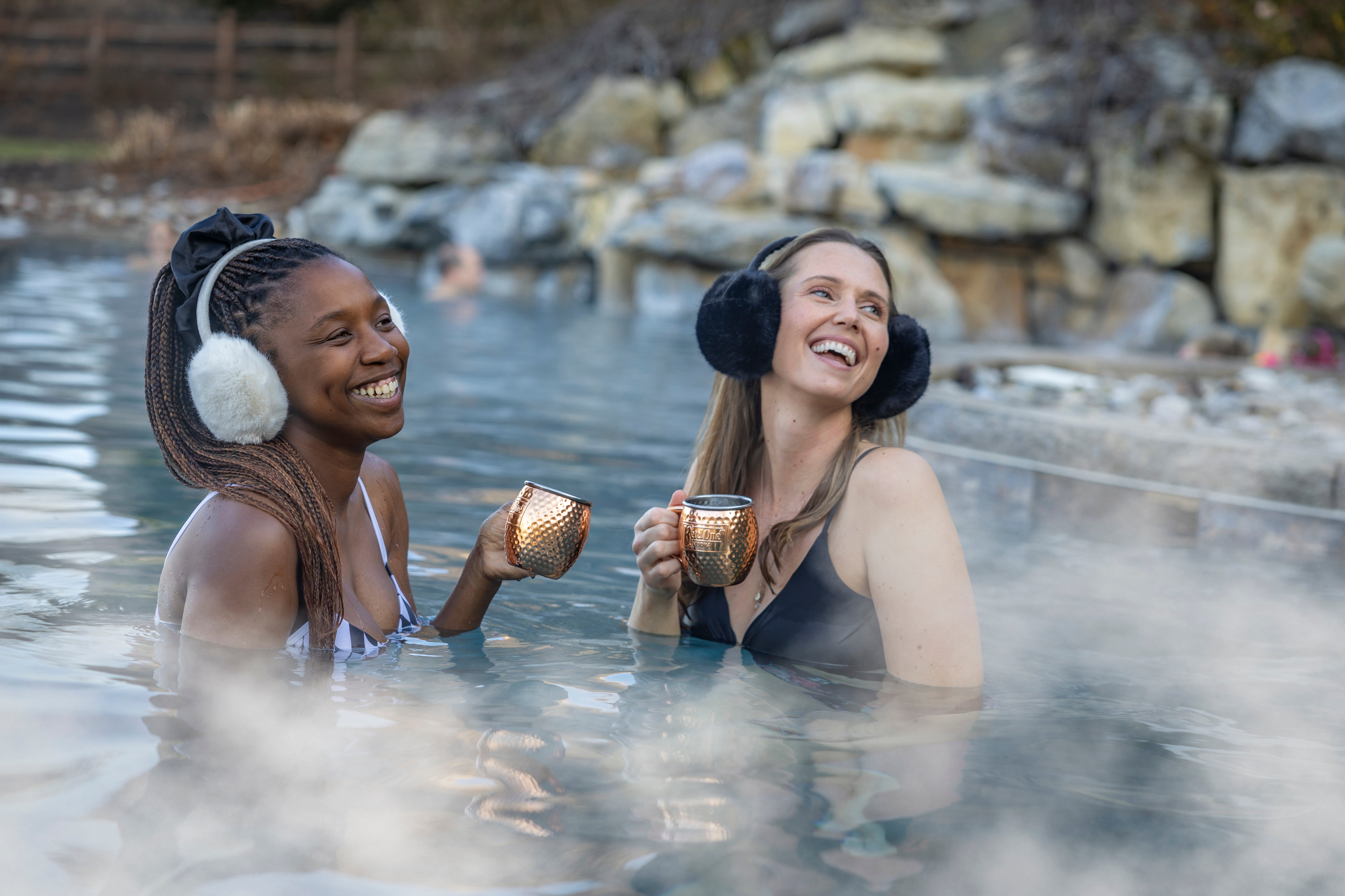 Two women in snow pool drinking mules. 