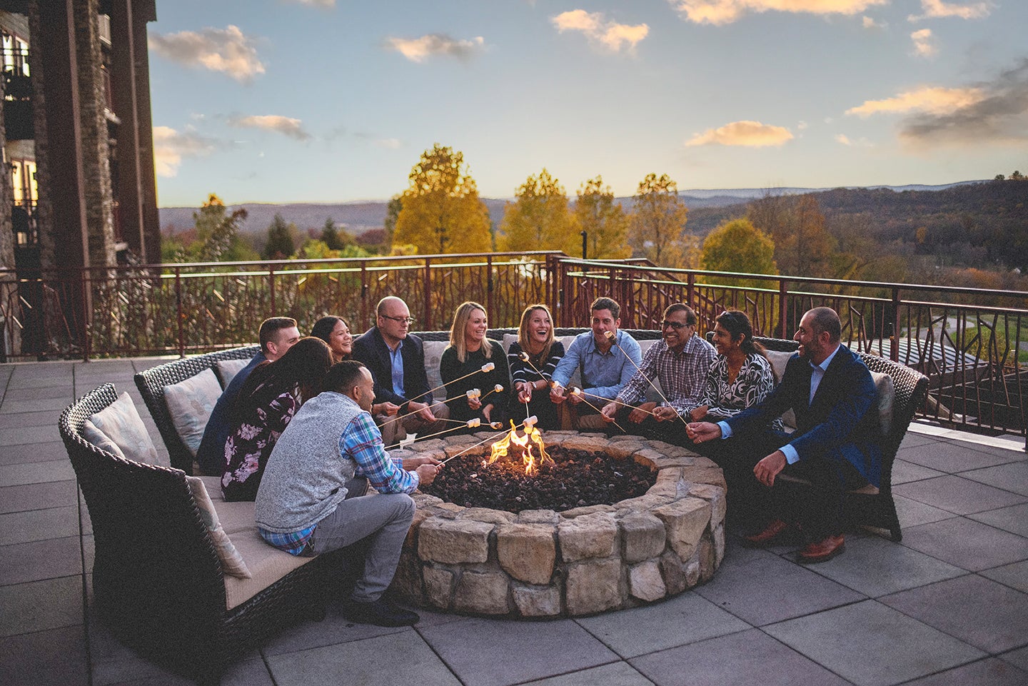 Group gathered around an outdoor fire pit at Crystal Springs Resort overlooking the mountains