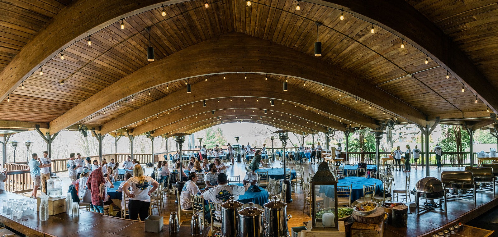 Guests enjoy a group dining experience beneath a vaulted wooden ceiling in an open-air pavilion at Crystal Springs Resort.