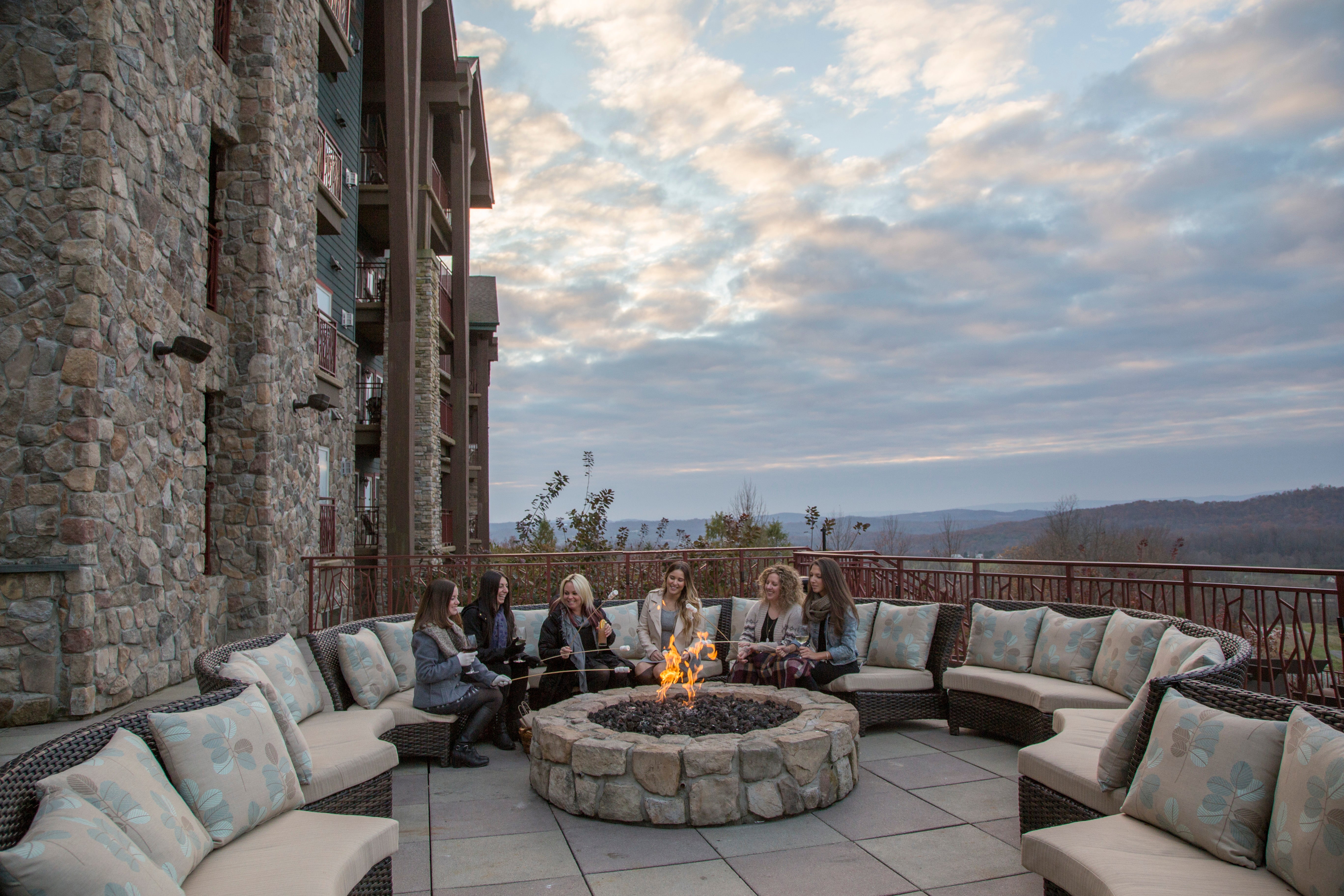 Six girlfriends sitting around firepit.