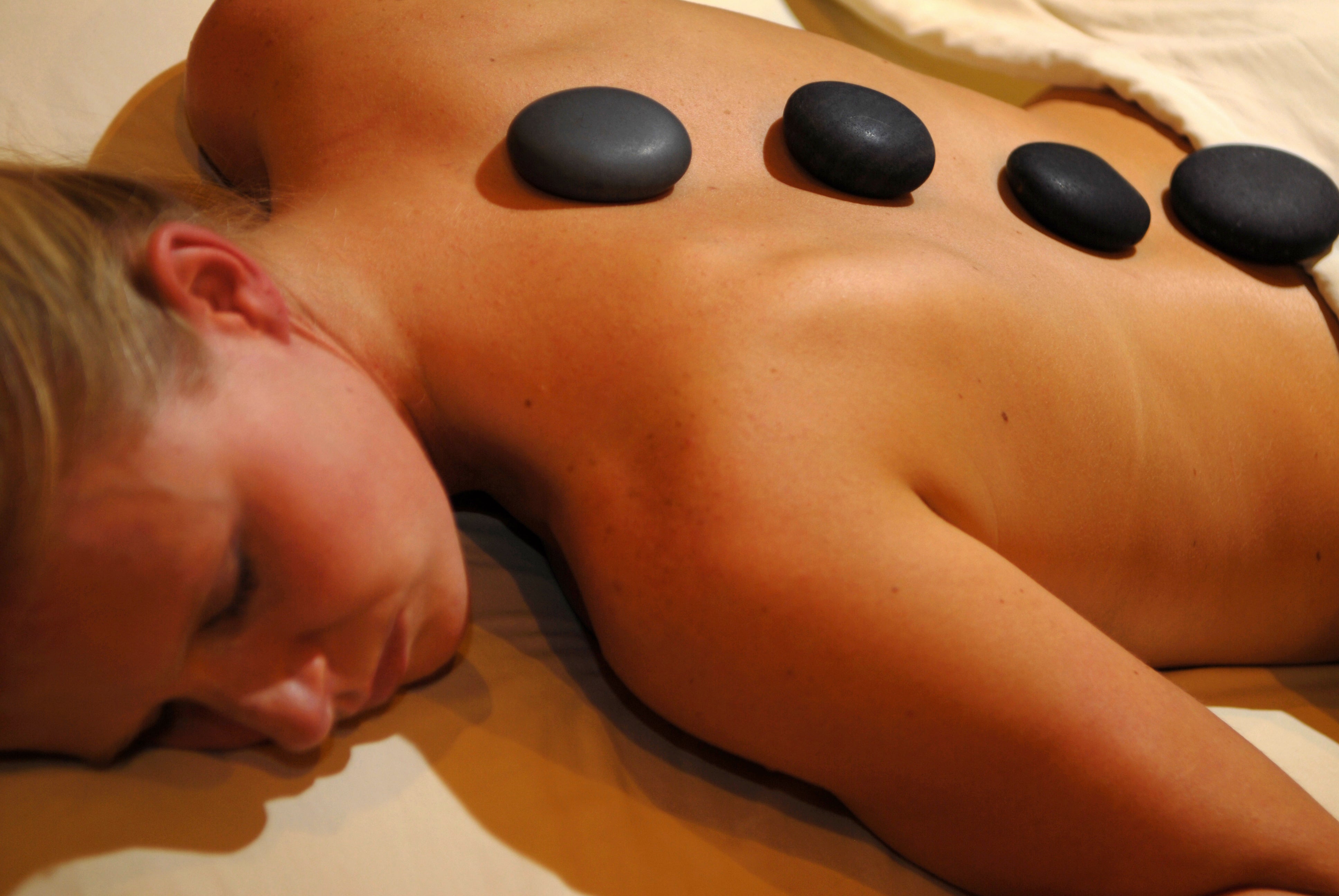 Woman receiving hot stones massage at Elements Spa.