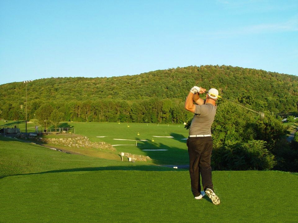 Golfer practicing at the driving range at Black Bear Golf Course