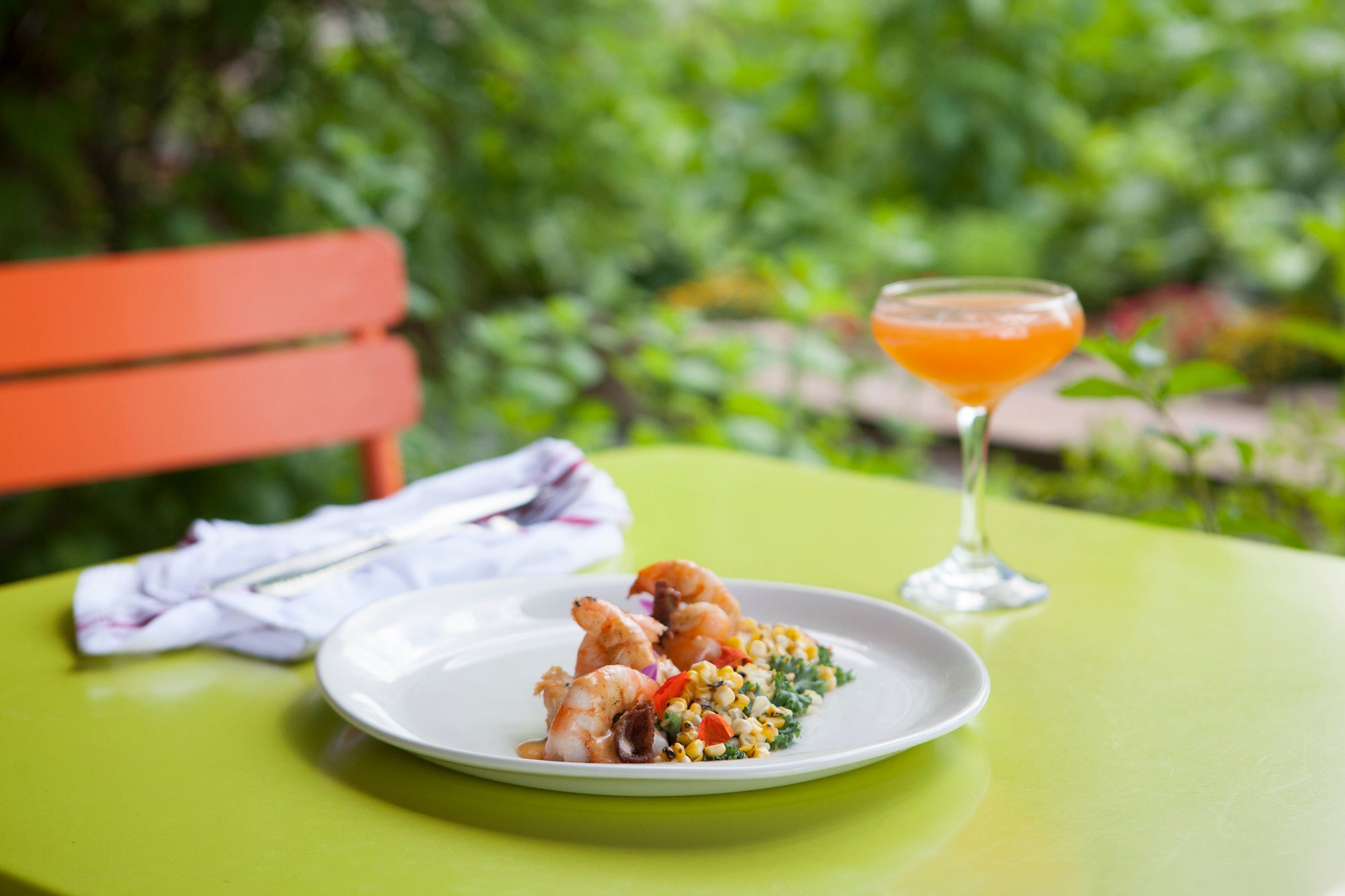 Food paired with orange colored cocktail in Chef's Garden.