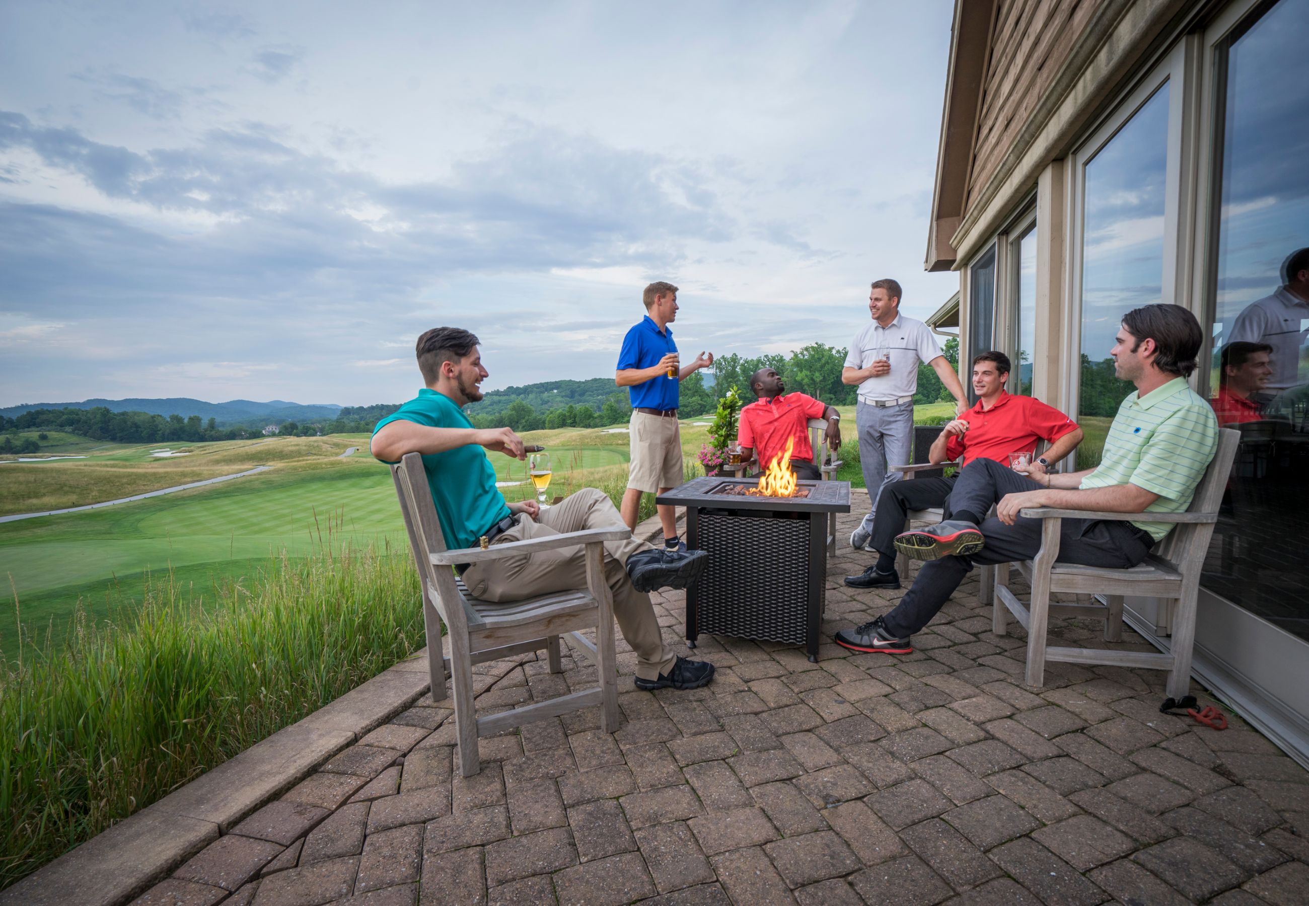 Guys sitting around a fire pit at a golf resort near NYC