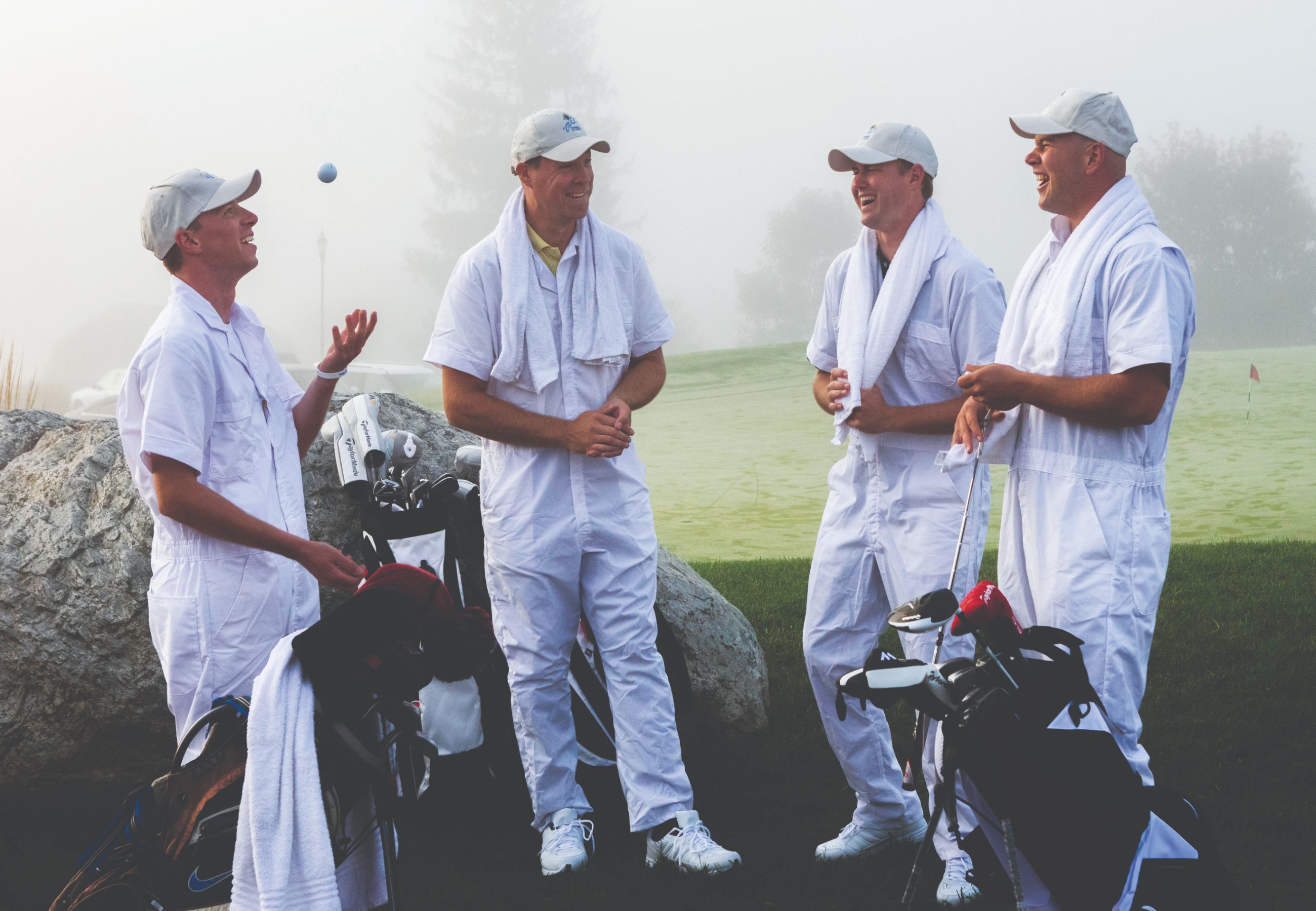 Four caddy's wearing white