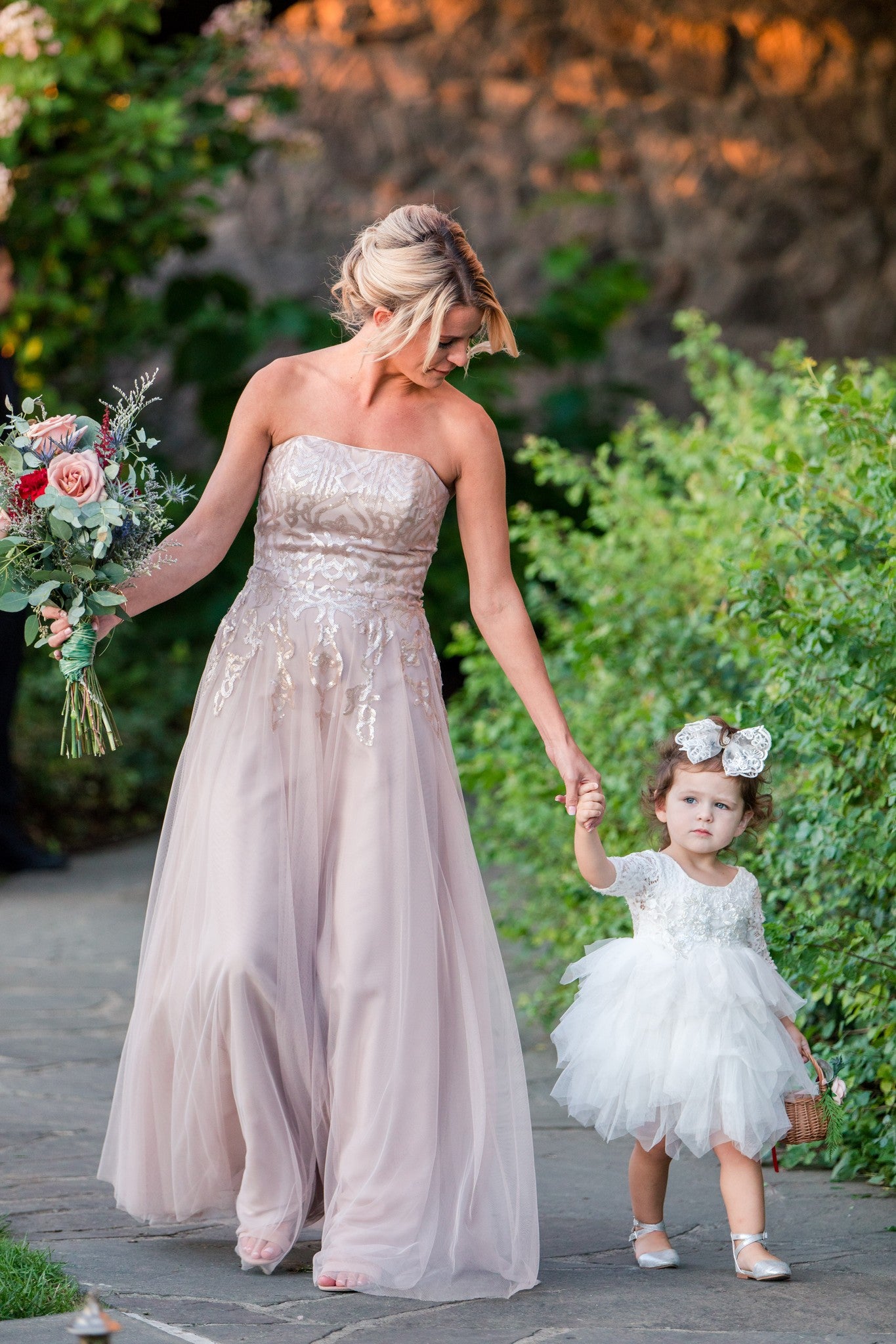 Beautiful bride walking with flower girl