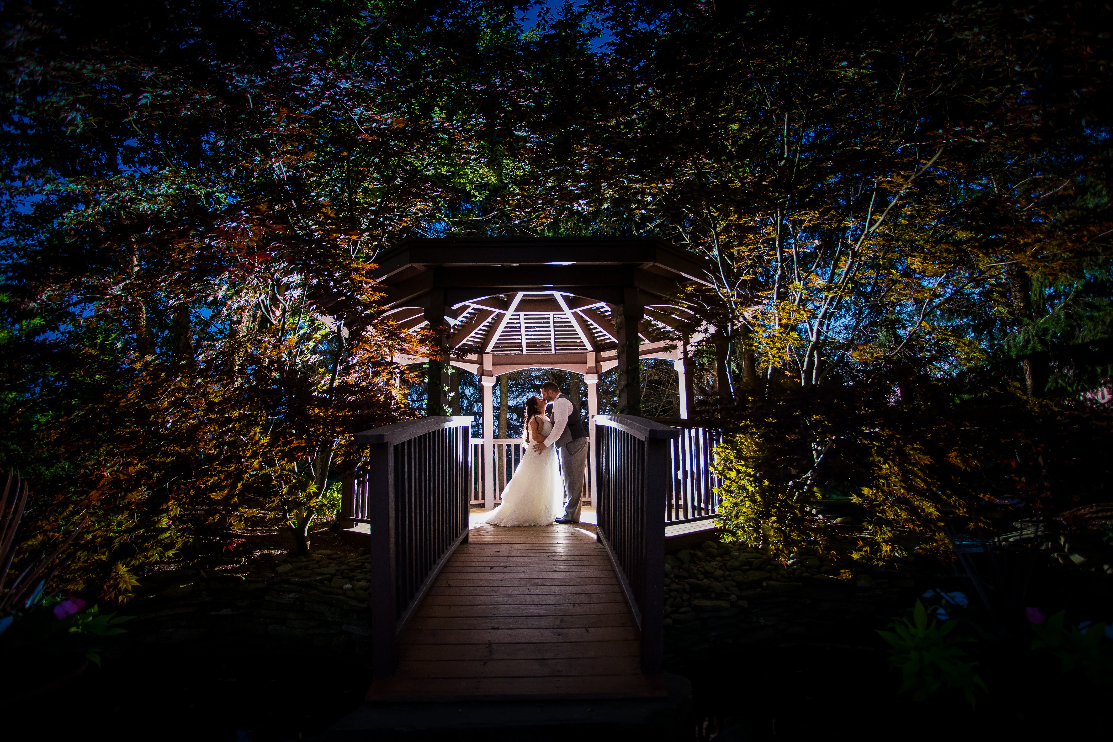 Wedding couple in lit up gazebo at night