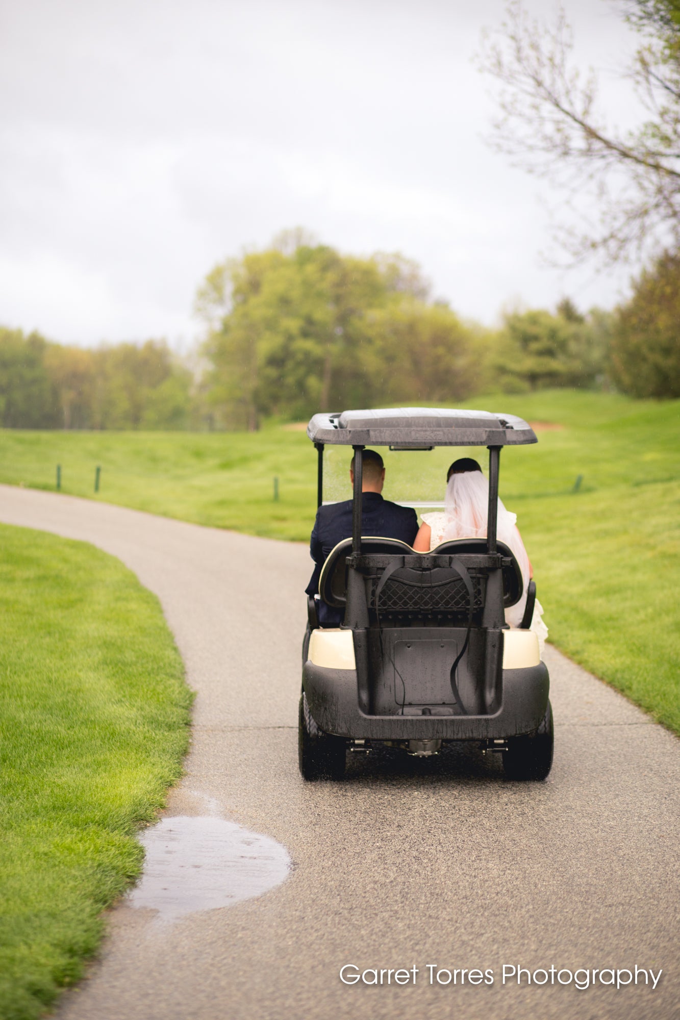 Bride and groom riding away in golf cart