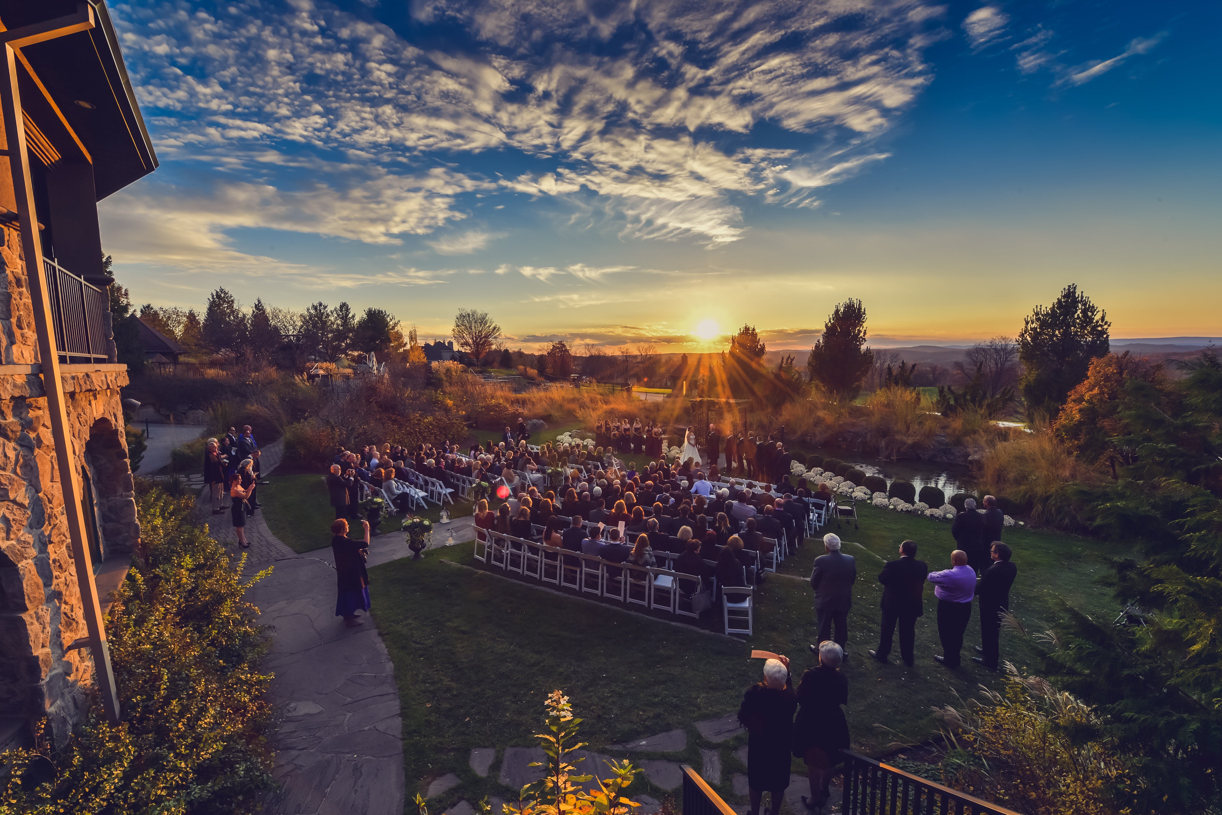 Sun setting on outdoor wedding ceremony at Grand Cascades Lodge.