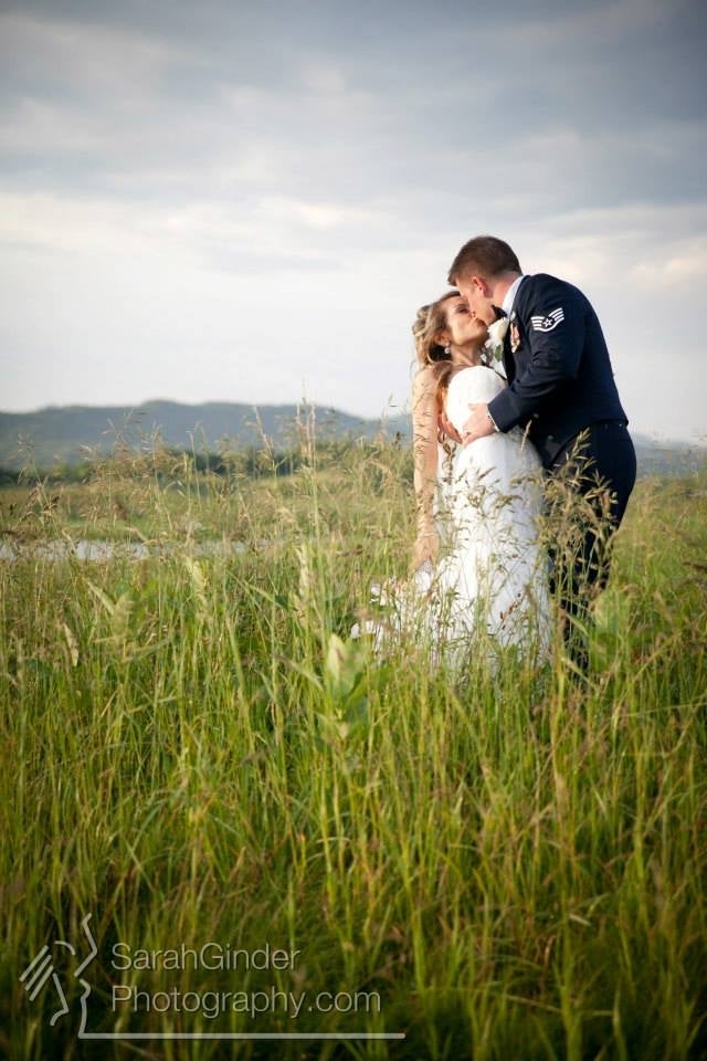 Man wearing his military uniform dips and kisses bride.
