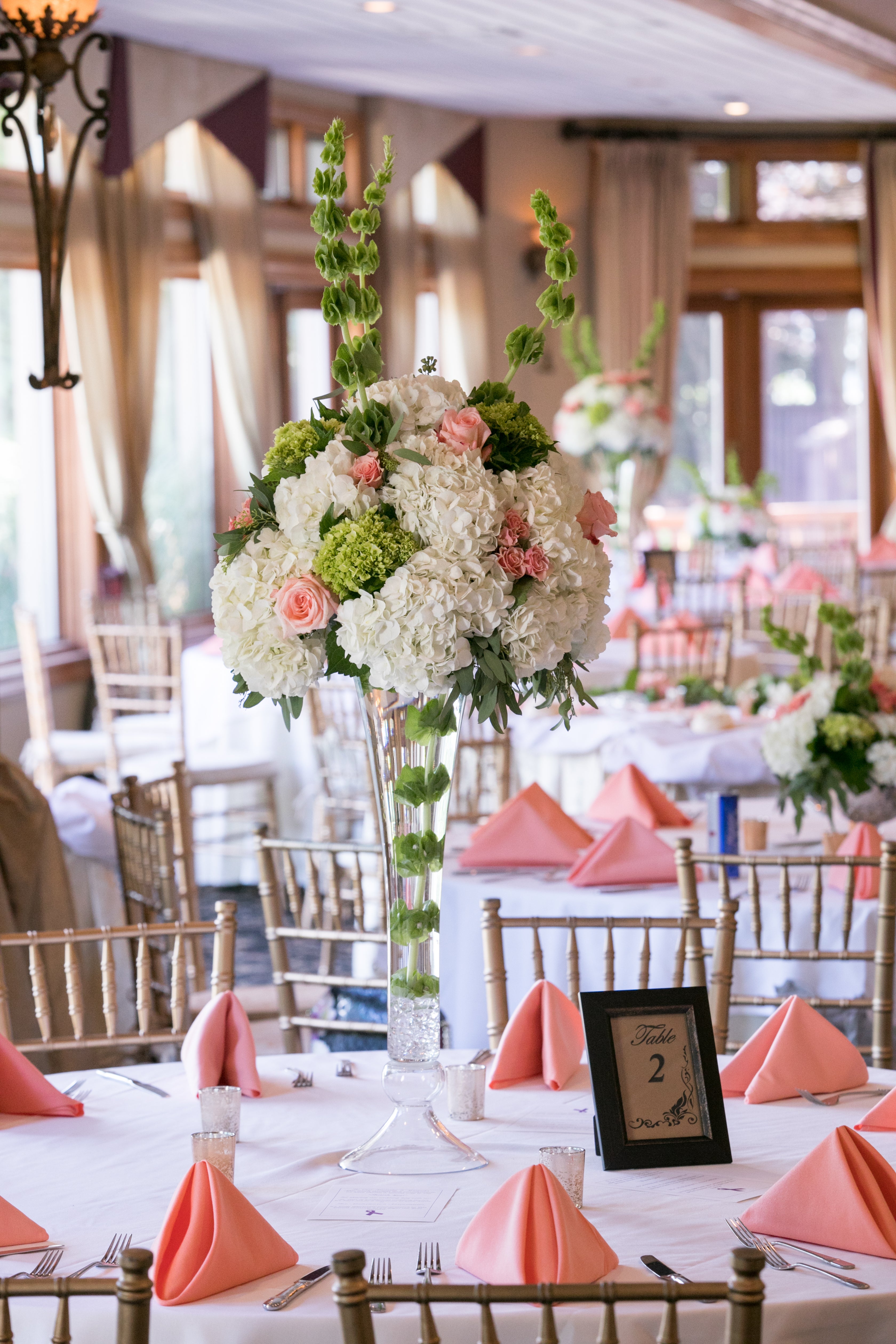Wedding tables decorated with pink napkins and flowers.