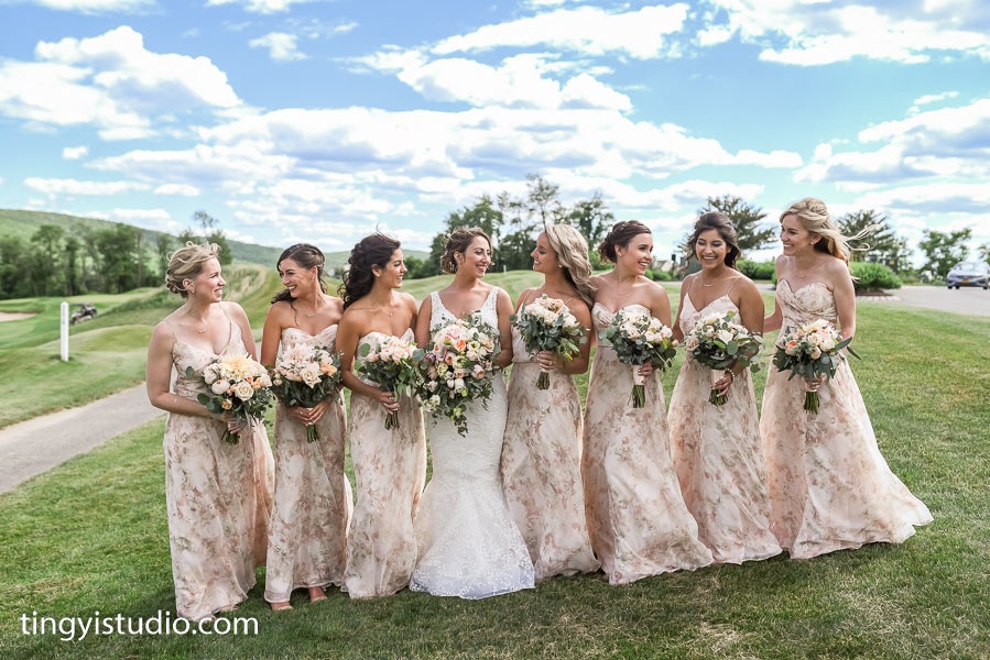 Bride standing with her bridesmaids who are wearing light pink dresses.