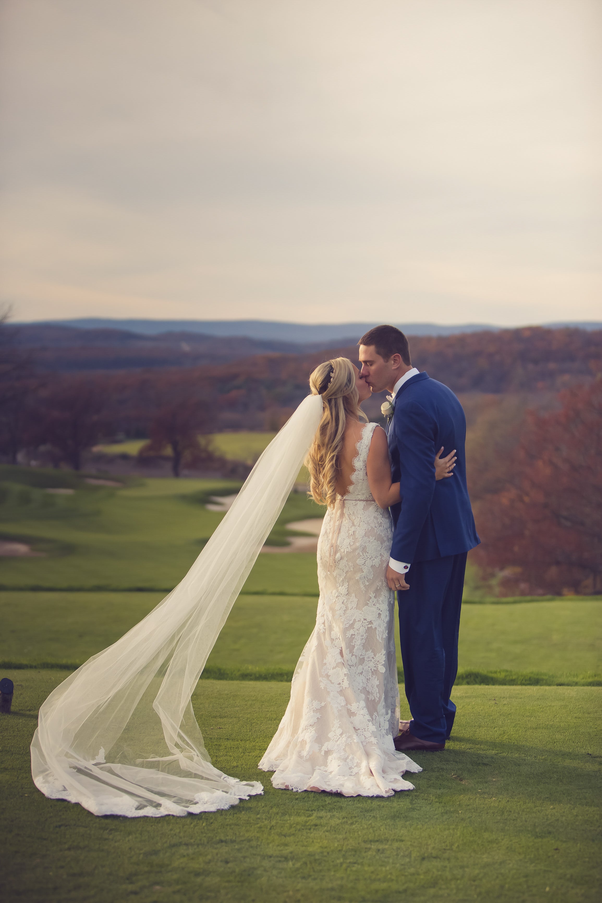 Bride and groom kissing on golf course at Crystal Springs Resort