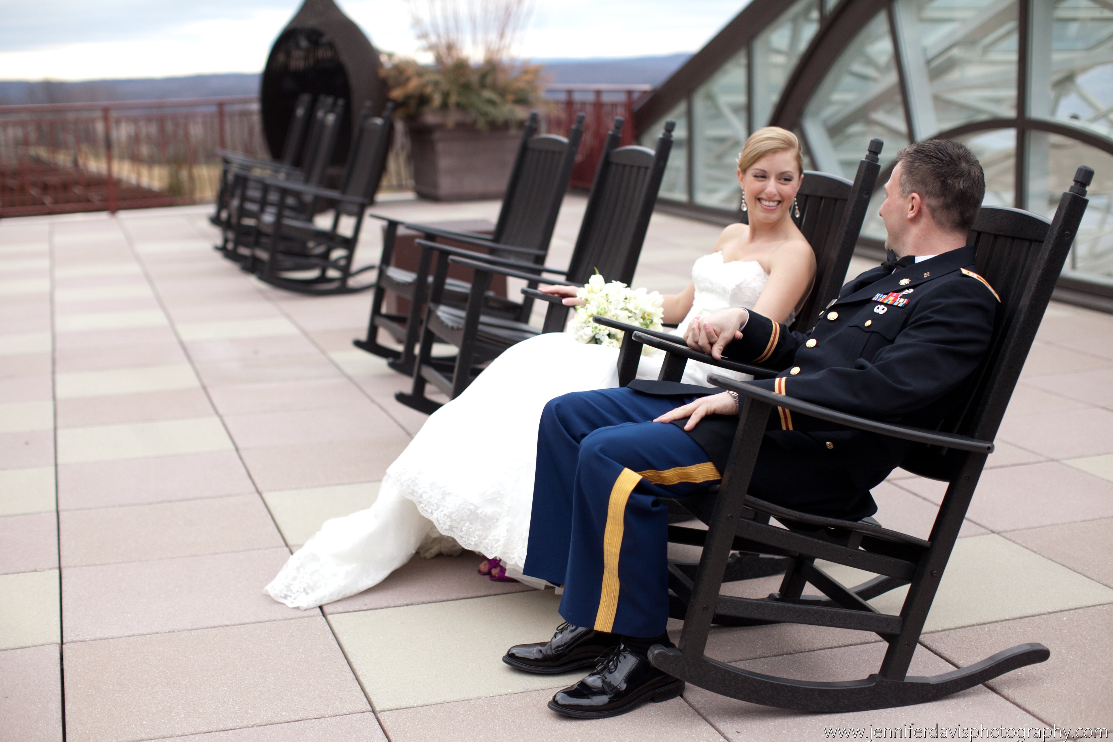 Military groom and bride sitting on rocking chairs on Fire &amp; Water Terrace