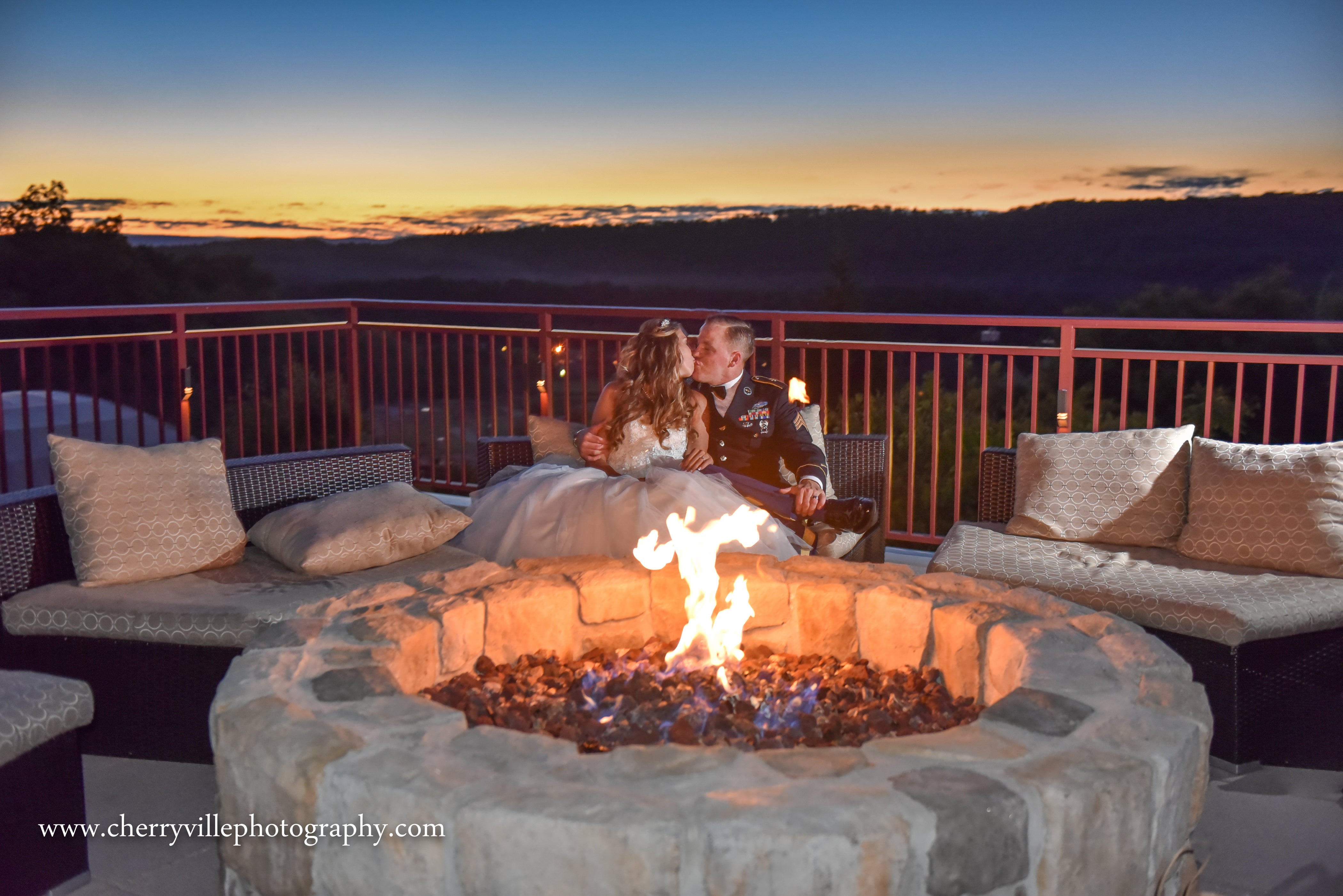 Bride and groom kissing over fire pit on Fire &amp; Water Terrace