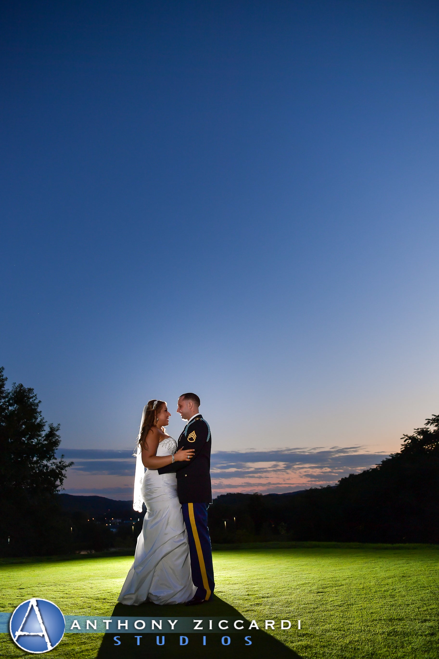 Military groom and bride in the spotlight at night