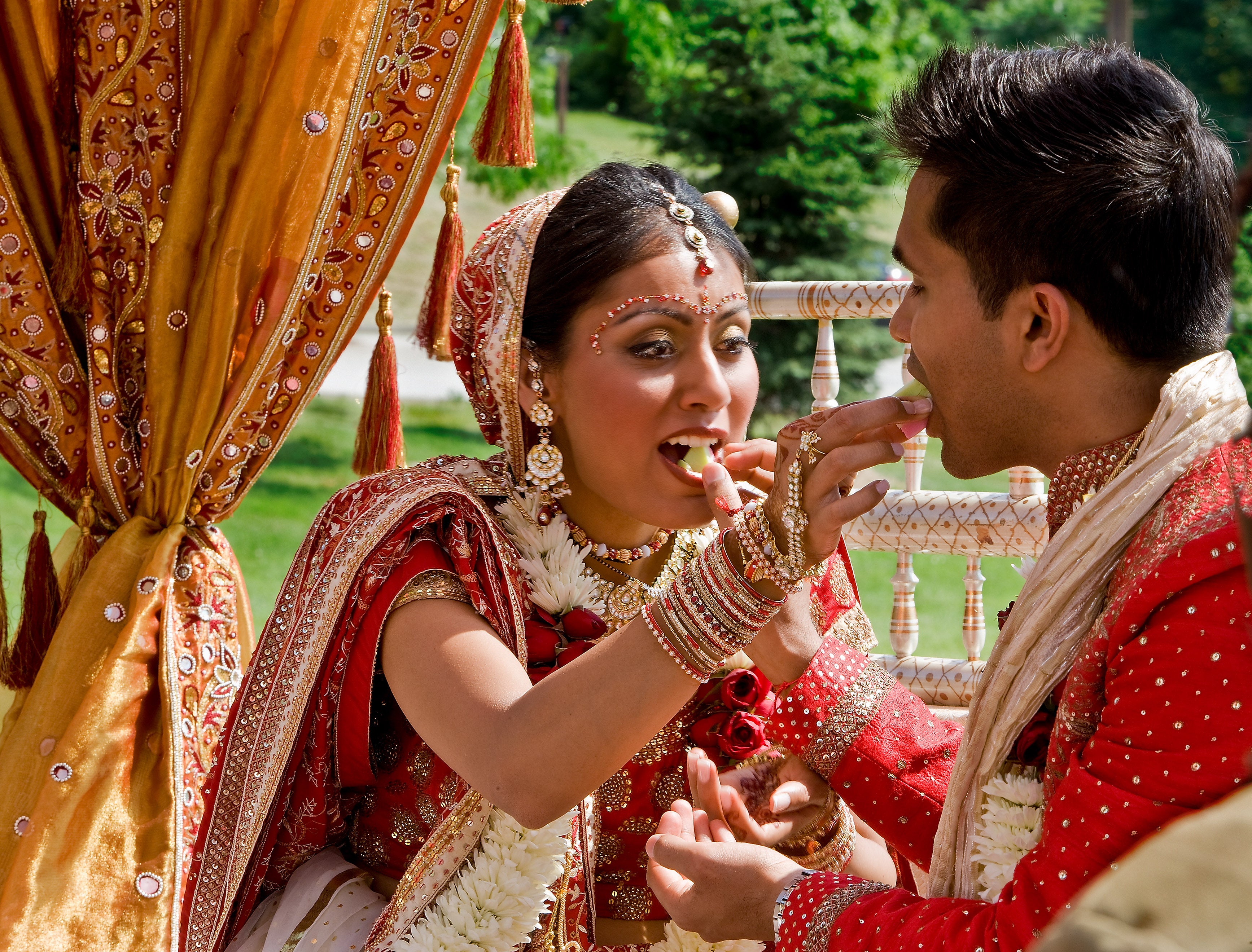 Indian bride and groom feeding each other