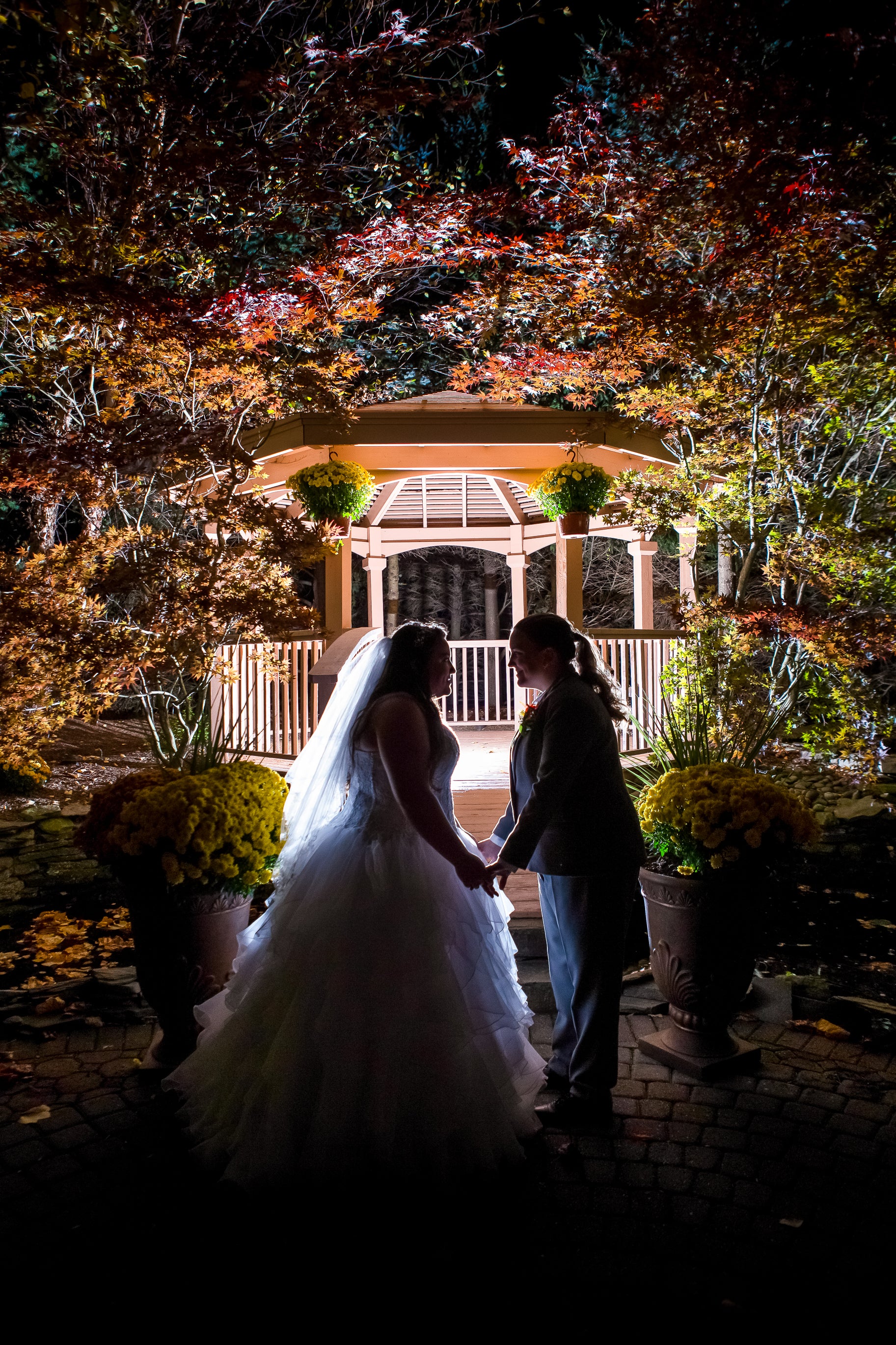 Brides in front of lit up Black Bear gazebo at night