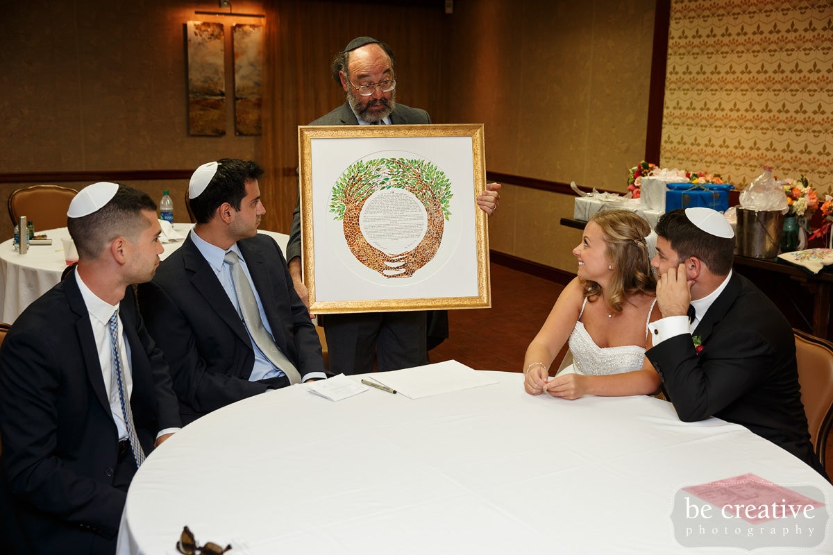 Man showing Ketubah at Jewish wedding
