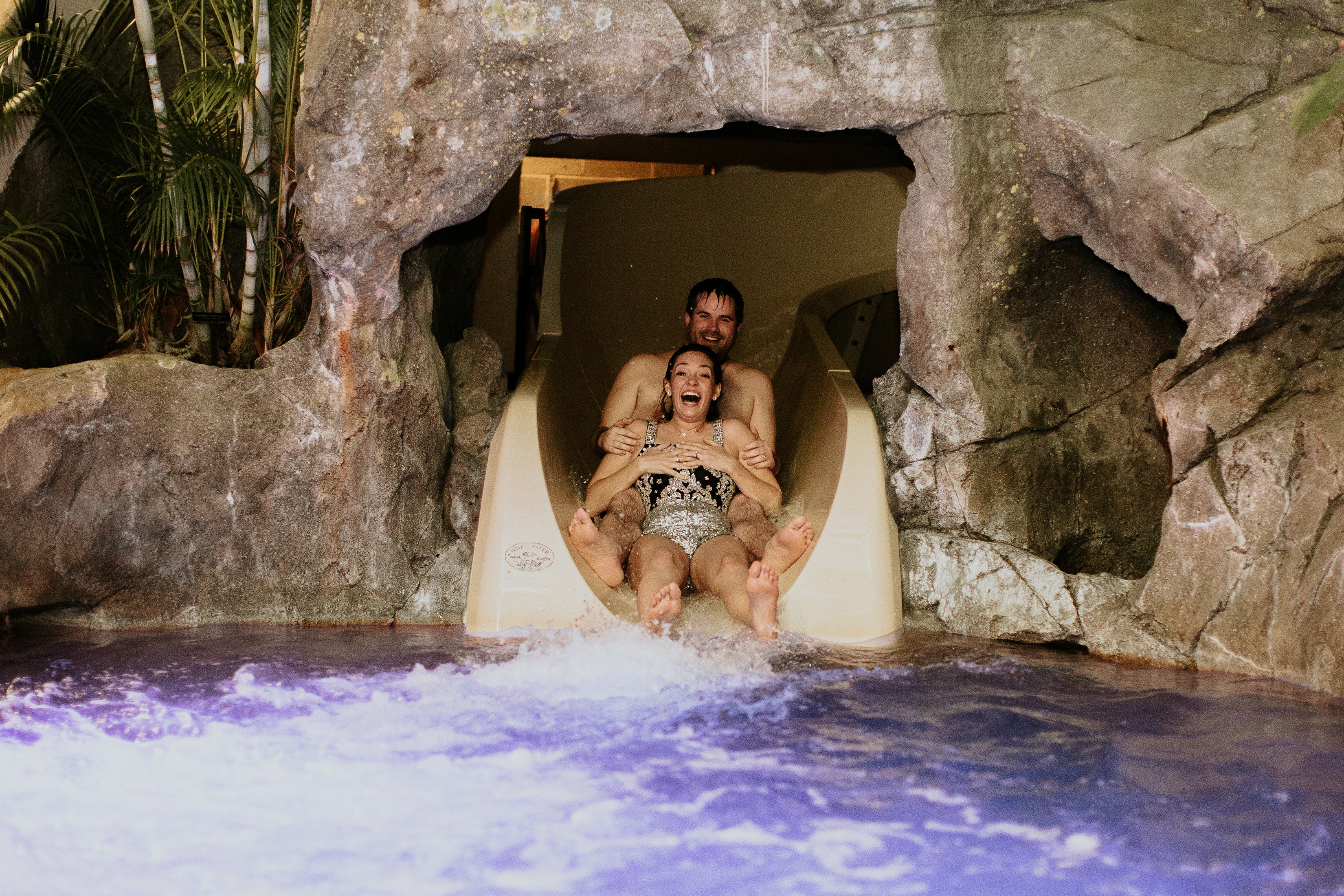 Bride and groom going down waterslide at Biosphere
