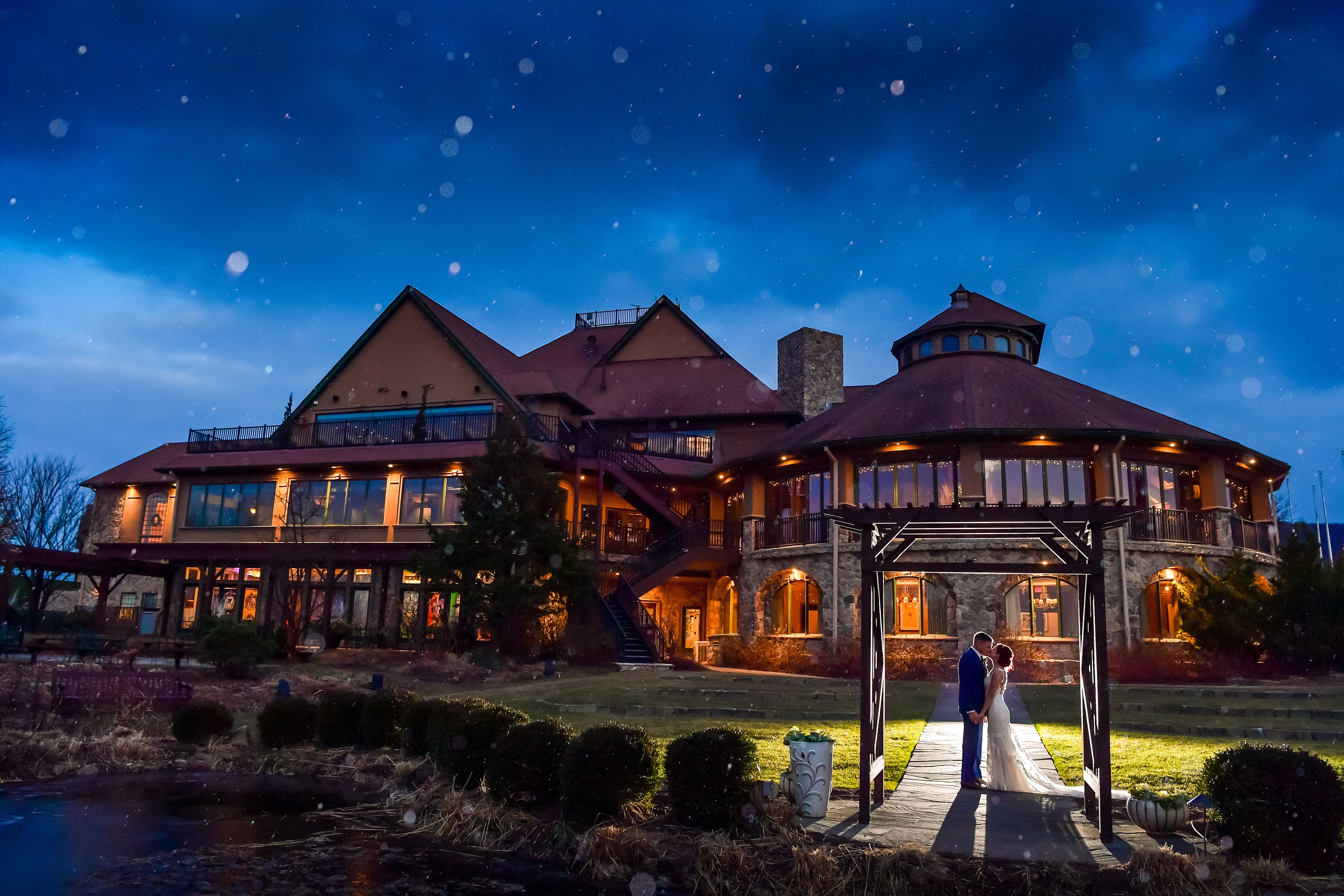 Bride and groom stand outside Crystal Springs Clubhouse at night.