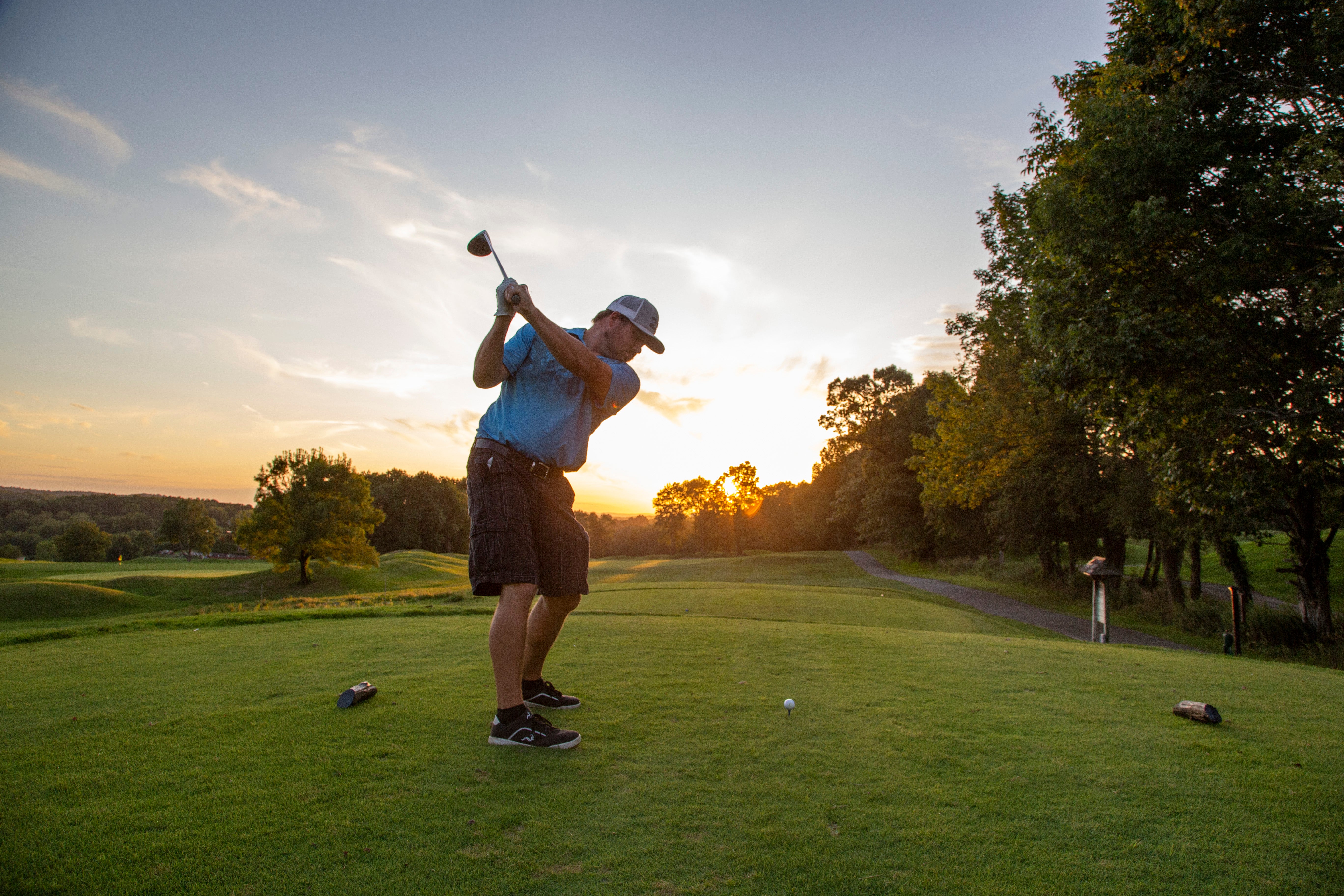 Man in blue shirt teeing off at Black Bear Golf Course