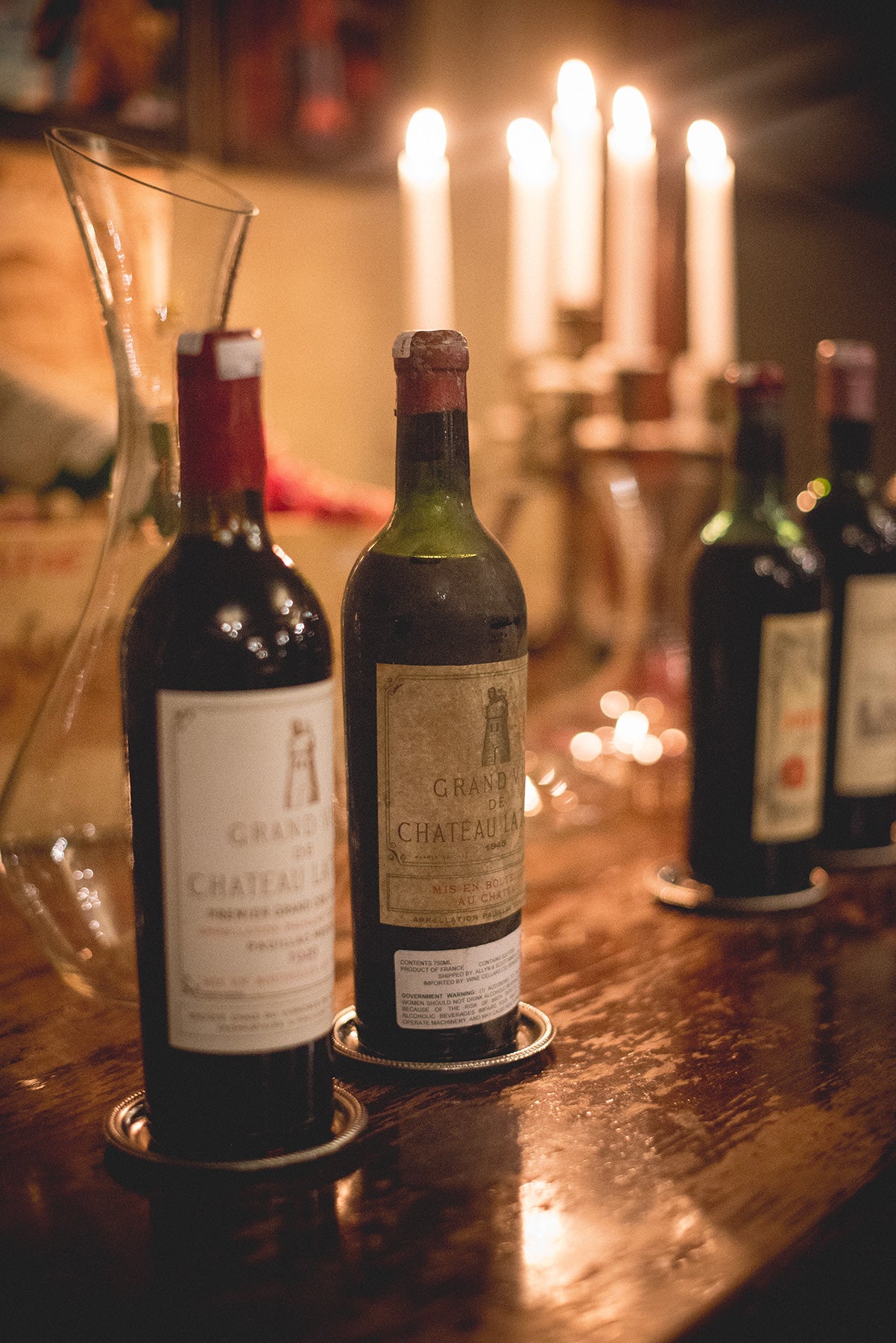 Two bottles of wine in front of decanter.