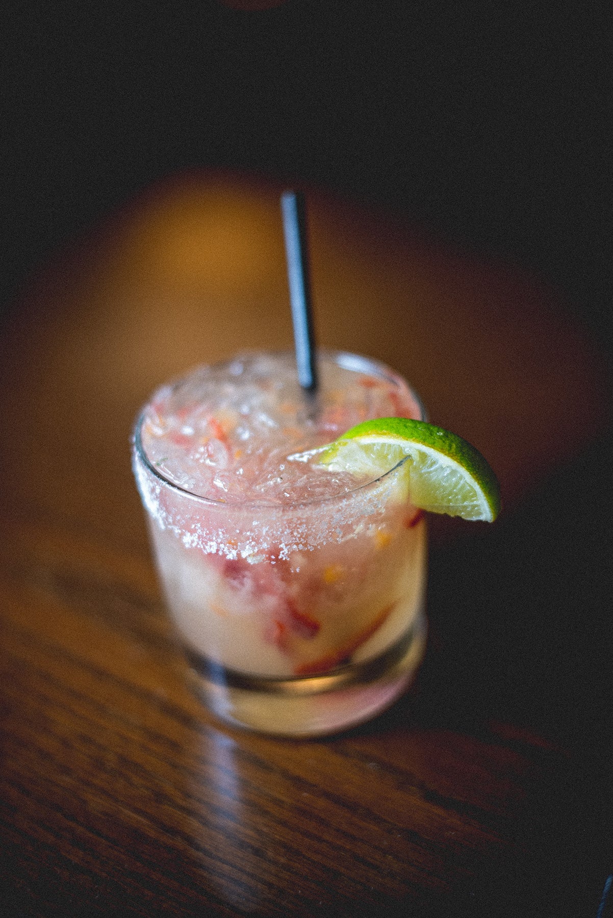 Cocktail in short round glass with lime wedge and salt.