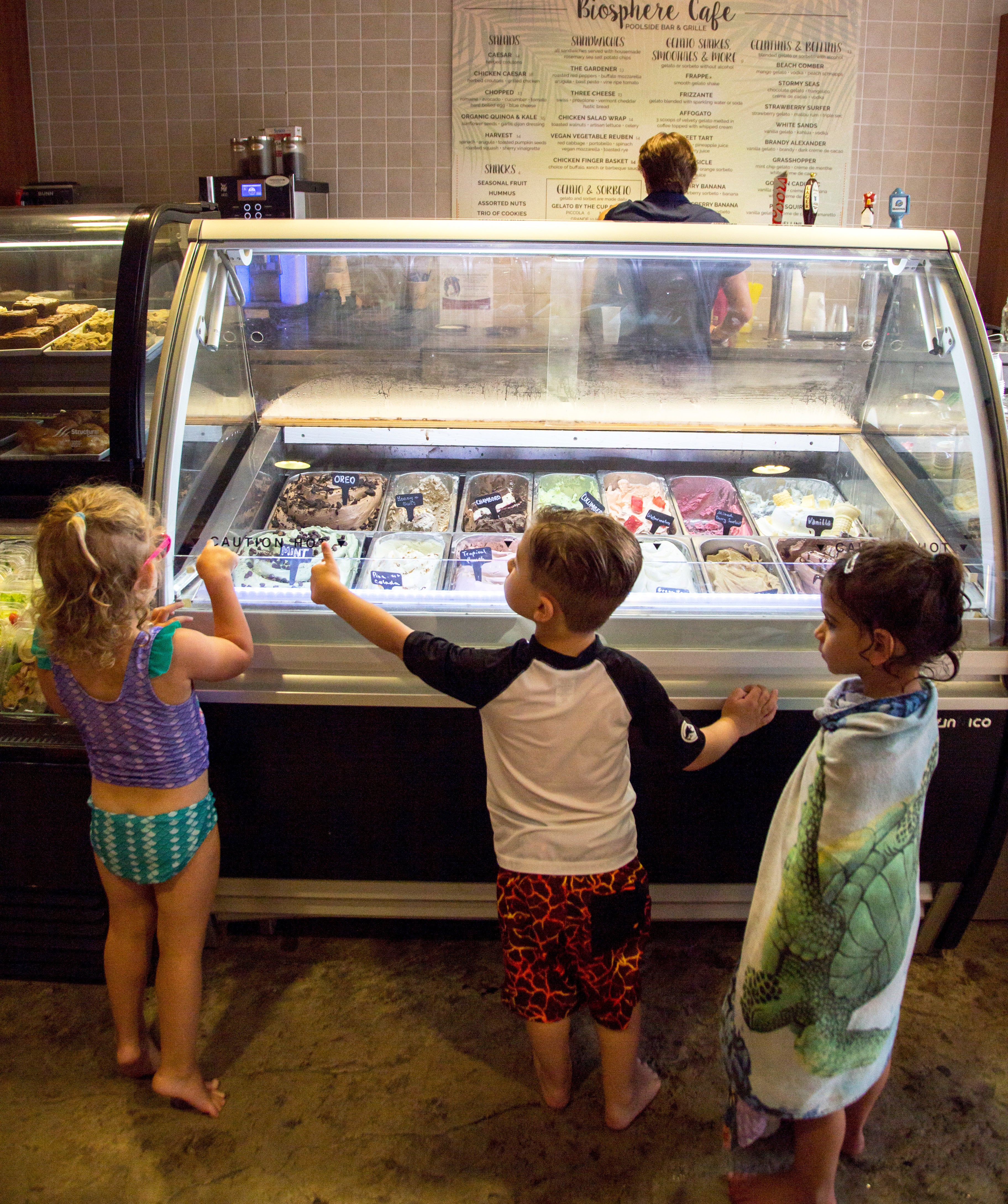 Three children standing in front of the gelato counter in the Biosphere cafe.