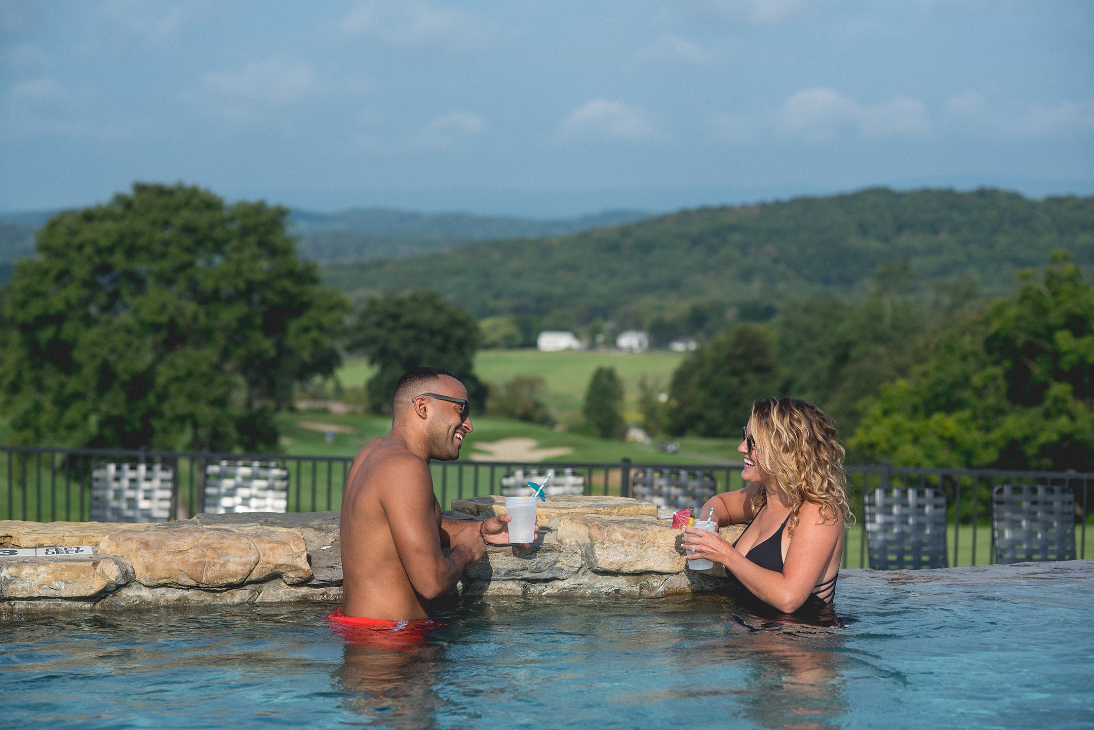 Couple sipping cocktails at the Vista 180 pool at Crystal Springs Resort